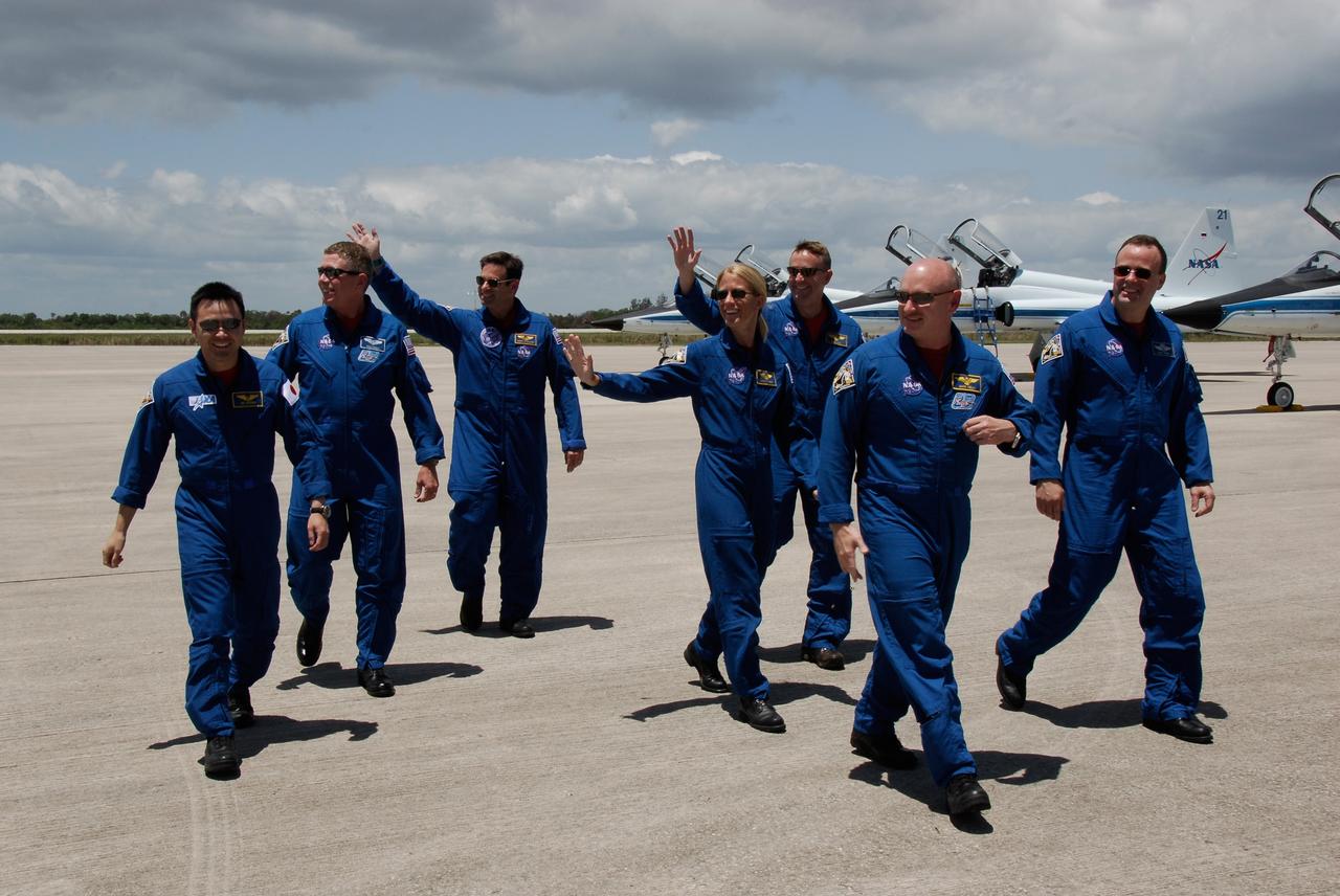 CAPE CANAVERAL, Fla. -- After greeting the media on their arrival on the Shuttle Landing Facility at NASA's Kennedy Space Center, the crew members of space shuttle Discovery's STS-124 mission wave and head for the van that will take them to crew quarters in the Operations and Checkout Building. They will be preparing for launch scheduled for 5:02 p.m. May 31. On the STS-124 mission, the crew of seven will deliver and install the Japanese Experiment Module – Pressurized Module and Japanese Remote Manipulator System. Photo credit: NASA/Kim Shiflett