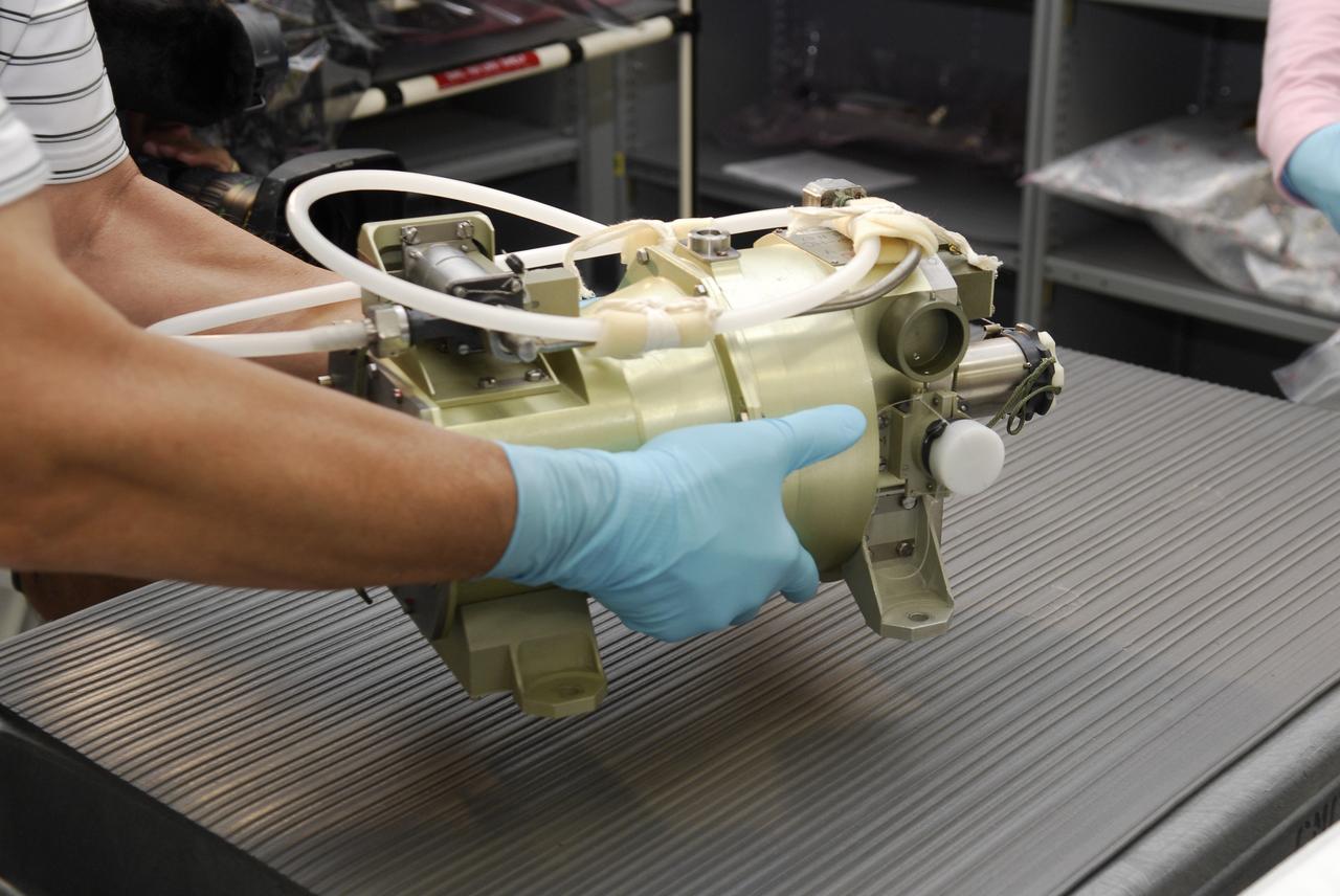 CAPE CANAVERAL, Fla. -- A replacement part for the Zvezda service module toilet on the International Space Station is inspected following its arrival at Kennedy Space Center. The toilet malfunctioned last week and was initially repaired by replacing a microprocessor valve. After the station crew members experienced additional difficulties with the toilet, they were directed to use Soyuz toilet facilities at first and are using the main toilet again after rigging a urine bypass. The spare toilet parts have been added to space shuttle Discovery’s manifest for delivery to the station on the STS-124 mission. On the 14-day mission, Discovery and its crew will deliver the Japan Aerospace Exploration Agency's Japanese Experiment Module – Pressurized Module and the Japanese Remote Manipulator System. Launch is scheduled for 5:02 p.m. EDT May 31. Photo credit: NASA/Kim Shiflett