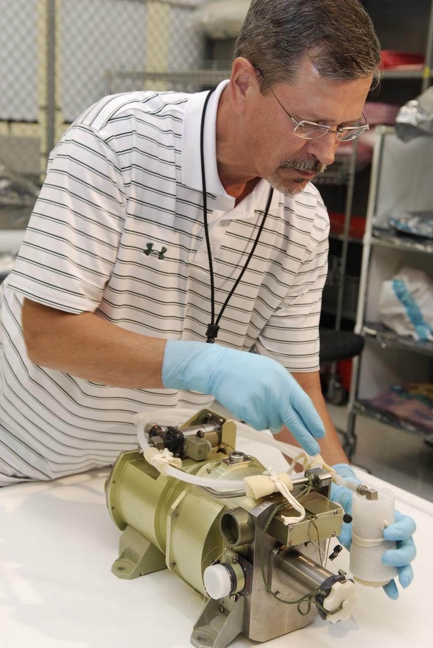 CAPE CANAVERAL, Fla. -- A technician inspects a replacement part for the Zvezda service module toilet on the International Space Station following its arrival at Kennedy Space Center. The toilet malfunctioned last week and was initially repaired by replacing a microprocessor valve. After the station crew members experienced additional difficulties with the toilet, they were directed to use Soyuz toilet facilities at first and are using the main toilet again after rigging a urine bypass. The spare toilet parts have been added to space shuttle Discovery’s manifest for delivery to the station on the STS-124 mission. On the 14-day mission, Discovery and its crew will deliver the Japan Aerospace Exploration Agency's Japanese Experiment Module – Pressurized Module and the Japanese Remote Manipulator System. Launch is scheduled for 5:02 p.m. EDT May 31. Photo credit: NASA/Kim Shiflett