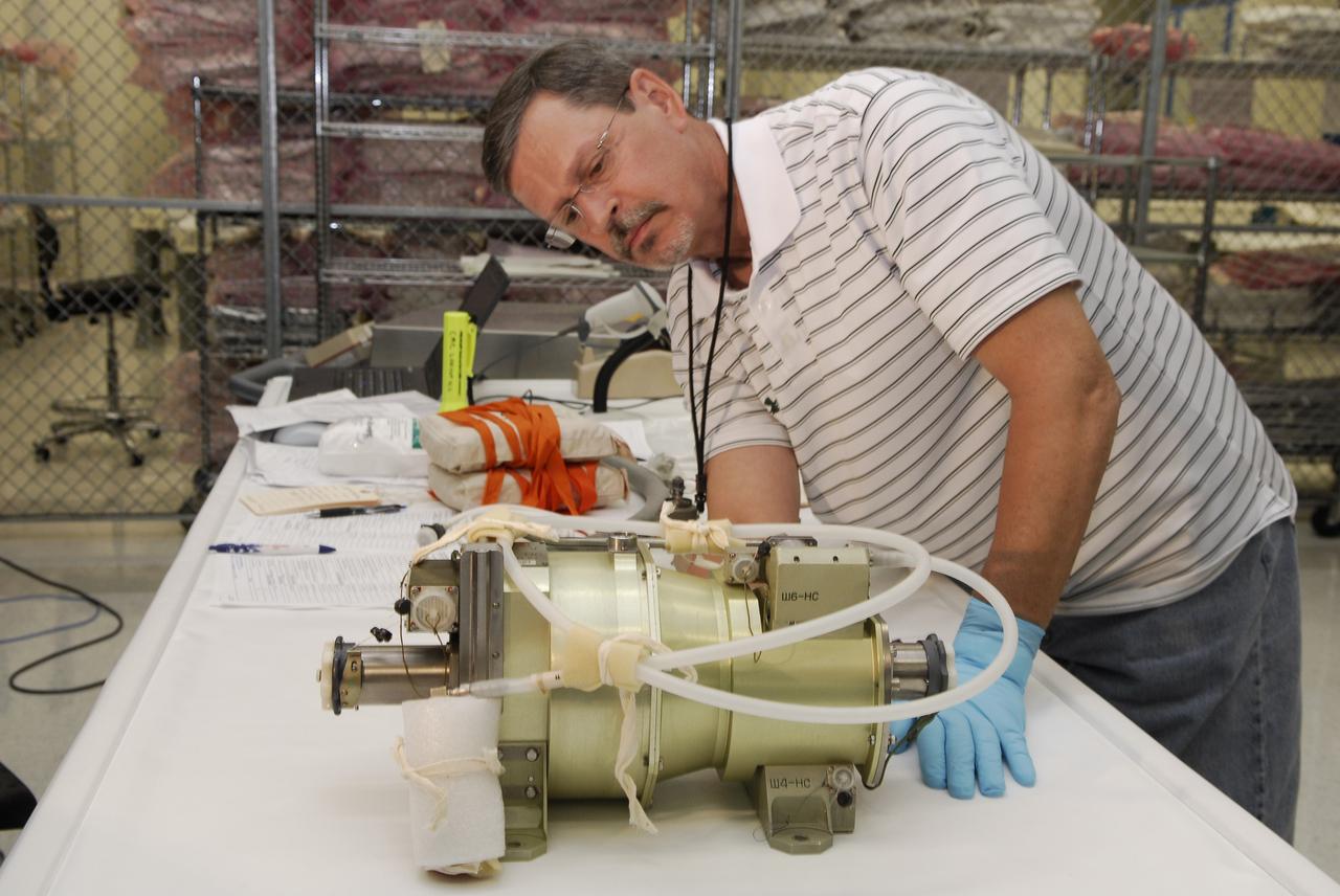 CAPE CANAVERAL, Fla. -- A technician inspects a replacement part for the Zvezda service module toilet on the International Space Station following its arrival at Kennedy Space Center. The toilet malfunctioned last week and was initially repaired by replacing a microprocessor valve. After the station crew members experienced additional difficulties with the toilet, they were directed to use Soyuz toilet facilities at first and are using the main toilet again after rigging a urine bypass. The spare toilet parts have been added to space shuttle Discovery’s manifest for delivery to the station on the STS-124 mission. On the 14-day mission, Discovery and its crew will deliver the Japan Aerospace Exploration Agency's Japanese Experiment Module – Pressurized Module and the Japanese Remote Manipulator System. Launch is scheduled for 5:02 p.m. EDT May 31. Photo credit: NASA/Kim Shiflett