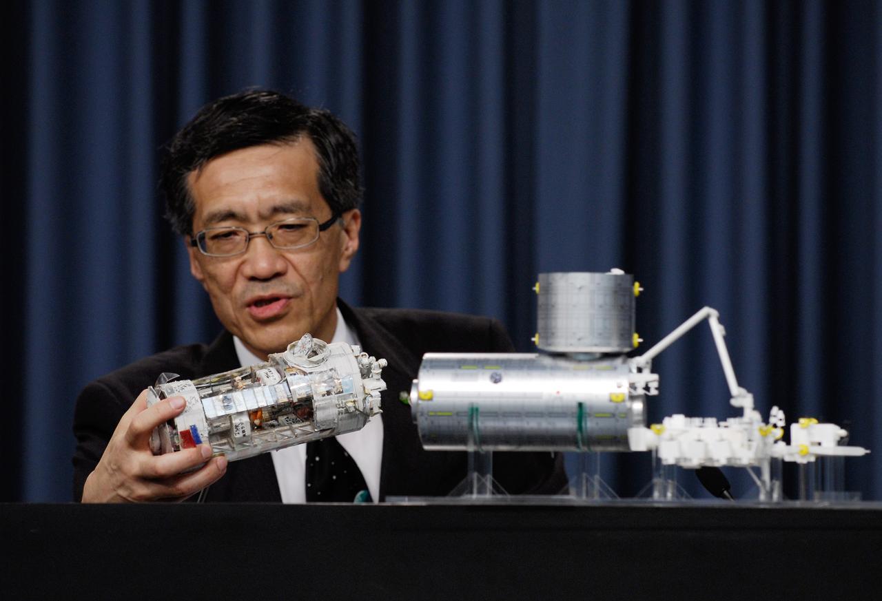 CAPE CANAVERAL, Fla. --    At a Japan Aerospace Exploration Agency briefing, Japanese Experiment Module Program Manager Yoshiyuki Hasegawa (right) explains how the Japanese Experiment Module – Pressurized Module will fit with the other segments on the International Space Station.  The final segment of the Kibo laboratory will be delivered to the space station on the STS-124 mission, which is scheduled to launch May 31.  Photo credit:  NASA/Kim Shiflett