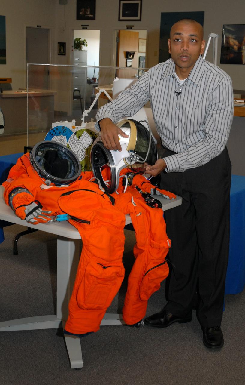 CAPE CANAVERAL, Fla. --  In the NASA News Center at NASA's Kennedy Space Center, Shuttle Crew Escape System Manager KC Chhipwadia describes for the media the elements of the helmet that is part of the launch and entry suit (seen on the table) used by shuttle crews during their missions. The helmet provides oxygen when needed plus a communication system.   Photo credit:  NASA/Amanda Diller