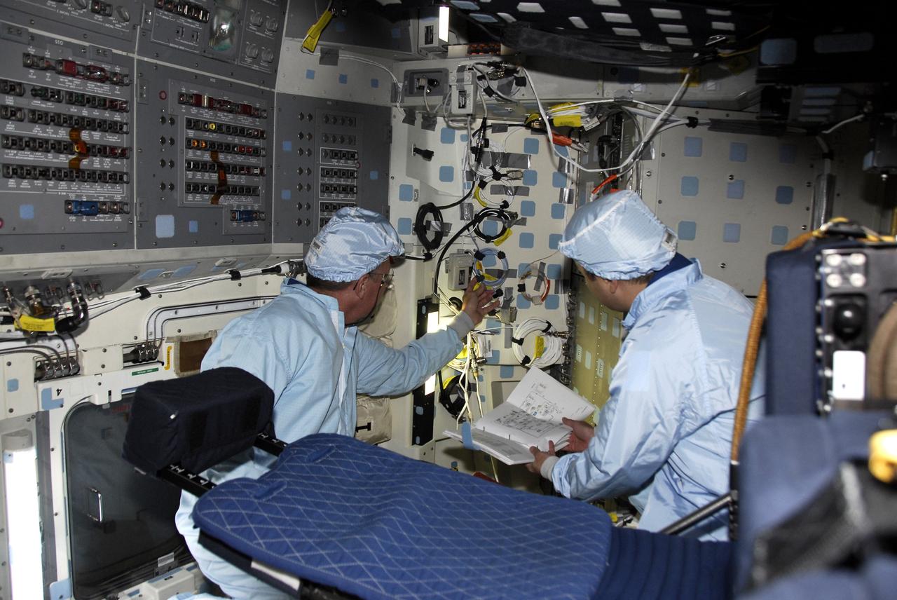 CAPE CANAVERAL, Fla. -- Members of the space shuttle Discovery's STS-124 crew inspect cables on Launch Pad 39A. From left are Mission Specialists Mike Fossum and Akihiko Hoshide, who represents the Japan Aerospace Exploration Agency. The crew is getting ready for launch at 5:02 p.m. on May 31. The STS-124 mission is the second of three flights launching components to complete the Japan Aerospace Exploration Agency's Kibo laboratory. The shuttle crew will install Kibo's large Japanese Pressurized Module and its remote manipulator system, or RMS. The 14-day flight includes three spacewalks. Photo credit: NASA/Kim Shiflett