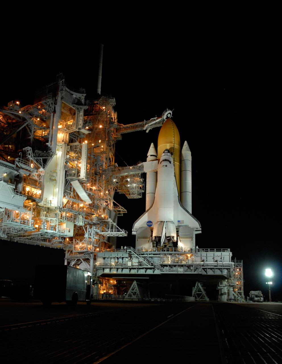 CAPE CANAVERAL, Fla. -- Against the dark sky, lights bathe space shuttle Discovery, revealed after rollback of the rotating service structure in preparation for launch on the STS-124 mission. First motion was at 8:33 p.m. and rollback was complete at 9:07 p.m. The rotating structure provides protected access to the shuttle for changeout and servicing of payloads at the pad. It is supported by a rotating bridge that pivots on a vertical axis on the west side of the pad's flame trench. After the RSS is rolled back, the orbiter is ready for fuel cell activation and external tank cryogenic propellant loading operations. The pad is cleared to the perimeter gate for operations to fill the external tank with about 500,000 gallons of cryogenic propellants used by the shuttle’s main engines. This is done at the pad approximately eight hours before the scheduled launch. Above the orange external tank is the oxygen vent hood, called the "beanie cap," at the end of the gaseous oxygen vent arm extending from the fixed service structure. Vapors are created as the liquid oxygen in the external tank boil off. The hood vents the gaseous oxygen vapors away from the space shuttle vehicle. Below is the orbiter access arm with the White Room at the end, flush against the shuttle. The White Room provides access into the shuttle. The STS-124 mission is the second of three flights launching components to complete the Japan Aerospace Exploration Agency's Kibo laboratory. The shuttle crew will install Kibo's large Japanese Pressurized Module and its remote manipulator system, or RMS. The 14-day flight includes three spacewalks. Launch is scheduled for 5:02 p.m. May 31. Photo credit: NASA/Troy Cryder
