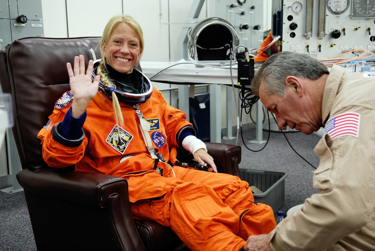 CAPE CANAVERAL, Fla. -- Crew members for space shuttle Discovery's STS-124 mission don their launch and entry suits before heading to Launch Pad 39A. A suit technician helps Mission Specialist Karen Nyberg with her boots. Nyberg is making her first shuttle flight. The STS-124 mission is the second of three flights launching components to complete the Japan Aerospace Exploration Agency's Kibo laboratory. The shuttle crew will install Kibo's large Japanese Pressurized Module and its remote manipulator system, or RMS. The 14-day flight includes three spacewalks. Launch is scheduled for 5:02 p.m. May 31. Photo credit: NASA/Kim Shiflett