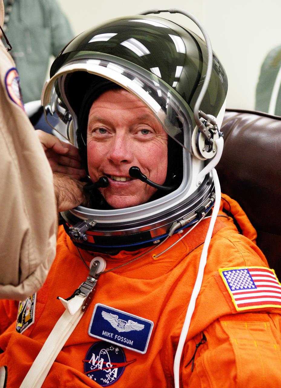 CAPE CANAVERAL, Fla. -- Crew members for space shuttle Discovery's STS-124 mission don their launch and entry suits before heading to Launch Pad 39A. A suit technician checks the communications cap inside Mission Specialist Mike Fossum's helmet. Fossum is making his second shuttle flight. The STS-124 mission is the second of three flights launching components to complete the Japan Aerospace Exploration Agency's Kibo laboratory. The shuttle crew will install Kibo's large Japanese Pressurized Module and its remote manipulator system, or RMS. The 14-day flight includes three spacewalks. Launch is scheduled for 5:02 p.m. May 31. Photo credit: NASA/Kim Shiflett