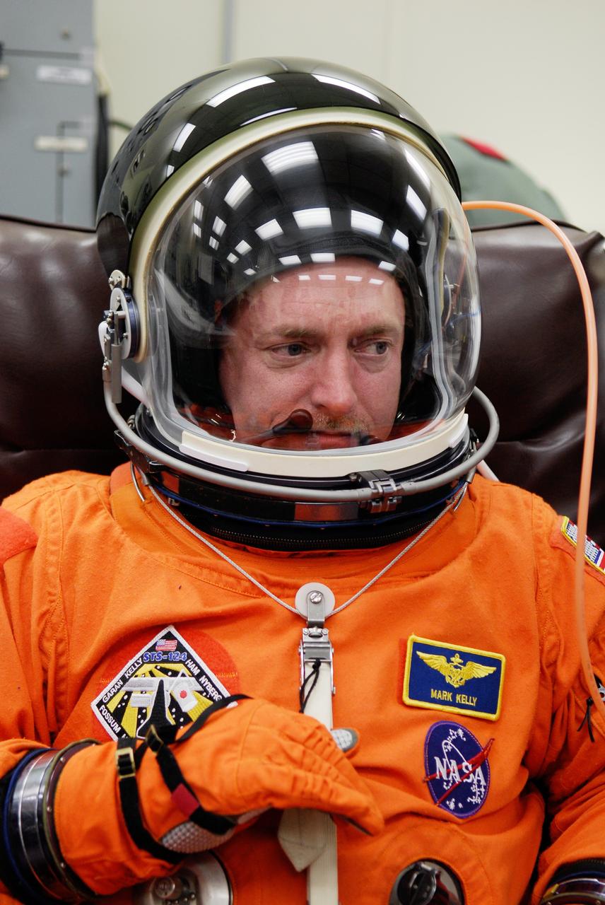 CAPE CANAVERAL, Fla. -- Crew members for space shuttle Discovery's STS-124 mission don their launch and entry suits before heading to Launch Pad 39A. Commander Mark Kelly dons his helmet to check the communications. The STS-124 mission is the second of three flights launching components to complete the Japan Aerospace Exploration Agency's Kibo laboratory. The shuttle crew will install Kibo's large Japanese Pressurized Module and its remote manipulator system, or RMS. The 14-day flight includes three spacewalks. Launch is scheduled for 5:02 p.m. May 31. Photo credit: NASA/Kim Shiflett