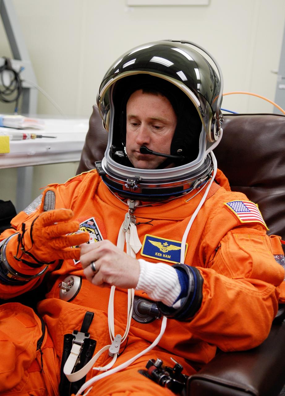 CAPE CANAVERAL, Fla. -- Crew members for space shuttle Discovery's STS-124 mission don their launch and entry suits before heading to Launch Pad 39A. Pilot Ken Ham adjusts his glove. The STS-124 mission is the second of three flights launching components to complete the Japan Aerospace Exploration Agency's Kibo laboratory. The shuttle crew will install Kibo's large Japanese Pressurized Module and its remote manipulator system, or RMS. The 14-day flight includes three spacewalks. Launch is scheduled for 5:02 p.m. May 31. Photo credit: NASA/Kim Shiflett