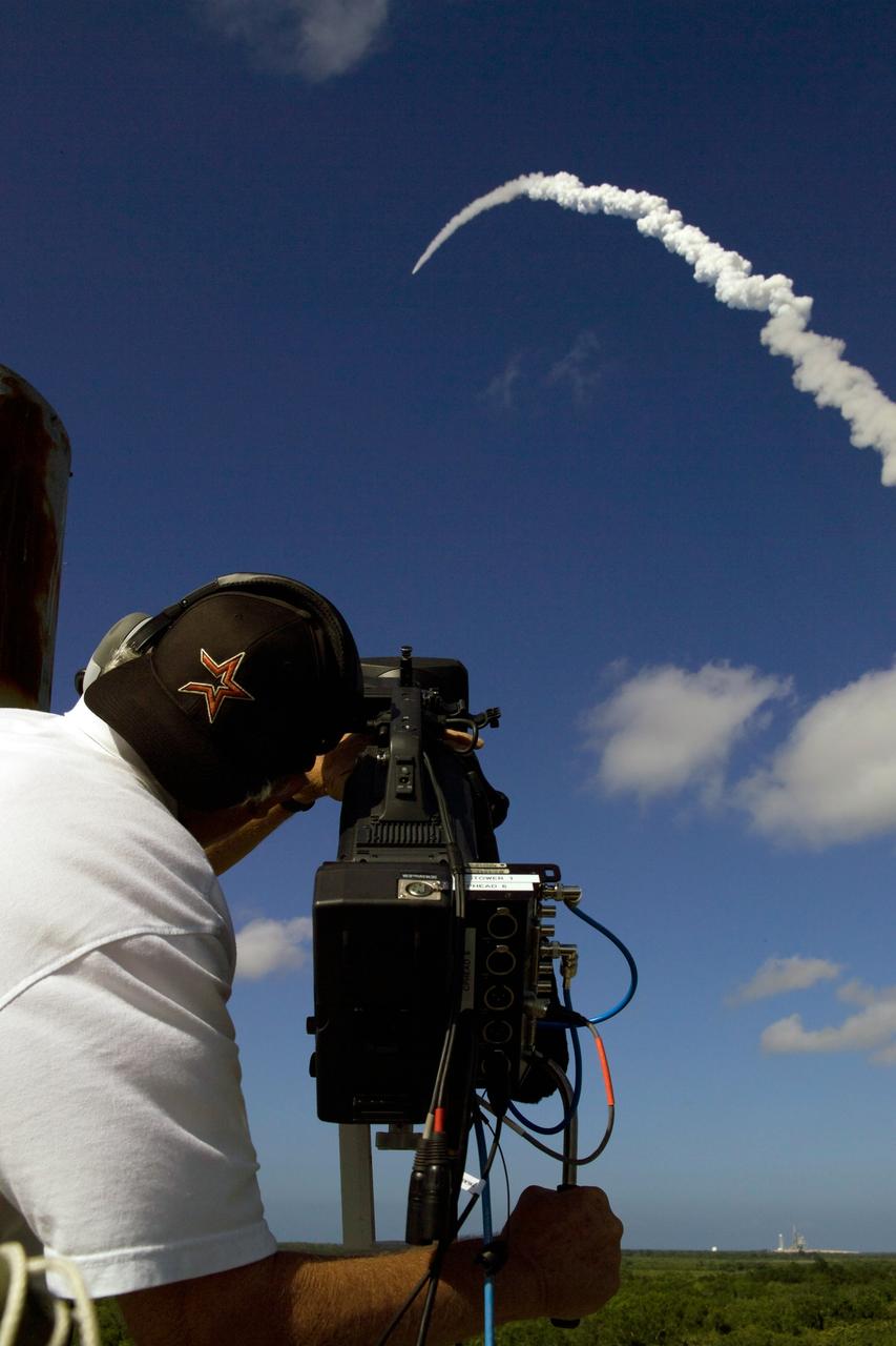 CAPE CANAVERAL, Fla. -- A videographer with NASA's Kennedy Space Center captures the arch of space shuttle Discovery's launch through the clear blue sky toward space on its STS-124 mission to the International Space Station. Launch was on time at 5:02 p.m. EDT. Discovery is making its 35th flight. The STS-124 mission is the 26th in the assembly of the space station. It is the second of three flights launching components to complete the Japan Aerospace Exploration Agency's Kibo laboratory. The shuttle crew will install Kibo's large Japanese Pressurized Module and its remote manipulator system, or RMS. The 14-day flight includes three spacewalks. Photo credit: NASA/Jeff Wolfe