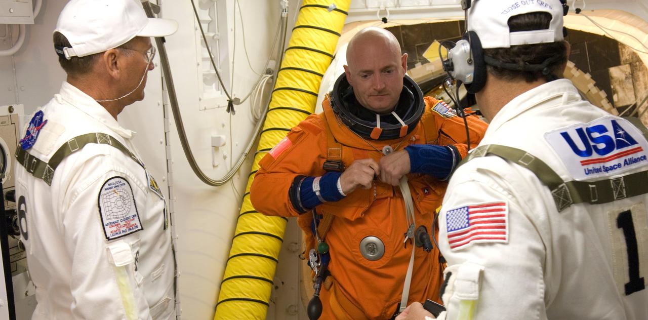 CAPE CANAVERAL, Fla. --In the White Room on Launch Pad 39A at NASA's Kennedy Space Center, STS-124 Commander Mark  Kelly adjusts his harness on the launch and entry suit before entering space shuttle Discovery for launch.  The White Room provides access into the shuttle.  Discovery is making its 35th flight.  The STS-124 mission is the 26th in the assembly of the space station.  It is the second of three flights launching components to complete the Japan Aerospace Exploration Agency's Kibo laboratory.  The shuttle crew will install Kibo's large Japanese Pressurized Module and its remote manipulator system, or RMS.  The 14-day flight includes three spacewalks. Photo credit: NASA/Tom Farrar, Kevin O'Connell, Scott Haun