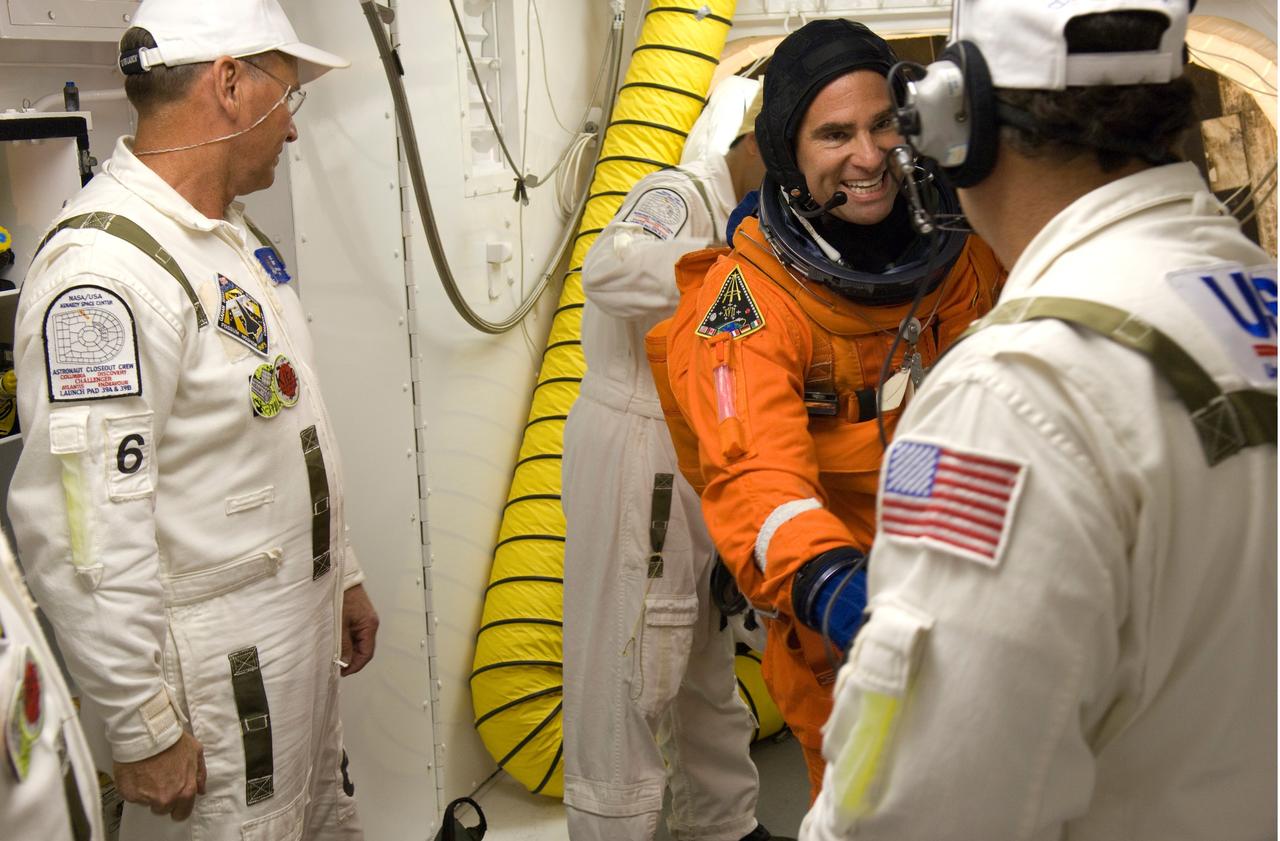 CAPE CANAVERAL, Fla. --In the White Room on Launch Pad 39A at NASA's Kennedy Space Center, STS-124 Mission Specialist Gregory Chamitoff talks with a suit technician before getting into the harness for his launch and entry suit.  The White Room provides access into the shuttle.  Discovery is making its 35th flight.  The STS-124 mission is the 26th in the assembly of the space station.  It is the second of three flights launching components to complete the Japan Aerospace Exploration Agency's Kibo laboratory.  The shuttle crew will install Kibo's large Japanese Pressurized Module and its remote manipulator system, or RMS.  The 14-day flight includes three spacewalks. Photo credit: NASA/Tom Farrar, Kevin O'Connell, Scott Haun