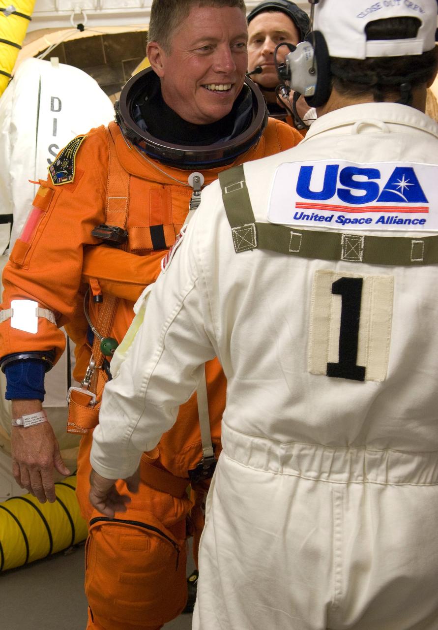CAPE CANAVERAL, Fla. --   In the White Room on Launch Pad 39A at NASA's Kennedy Space Center, STS-124 Mission Specialist Mike Fossum is helped by suit technicians to secure the harness over his launch and entry suit.  Behind Fossum is Pilot Ken Ham.  The White Room provides access into the shuttle.  Discovery is making its 35th flight.  The STS-124 mission is the 26th in the assembly of the space station.  It is the second of three flights launching components to complete the Japan Aerospace Exploration Agency's Kibo laboratory.  The shuttle crew will install Kibo's large Japanese Pressurized Module and its remote manipulator system, or RMS.  The 14-day flight includes three spacewalks. Photo credit: NASA/Tom Farrar, Kevin O'Connell, Scott Haun