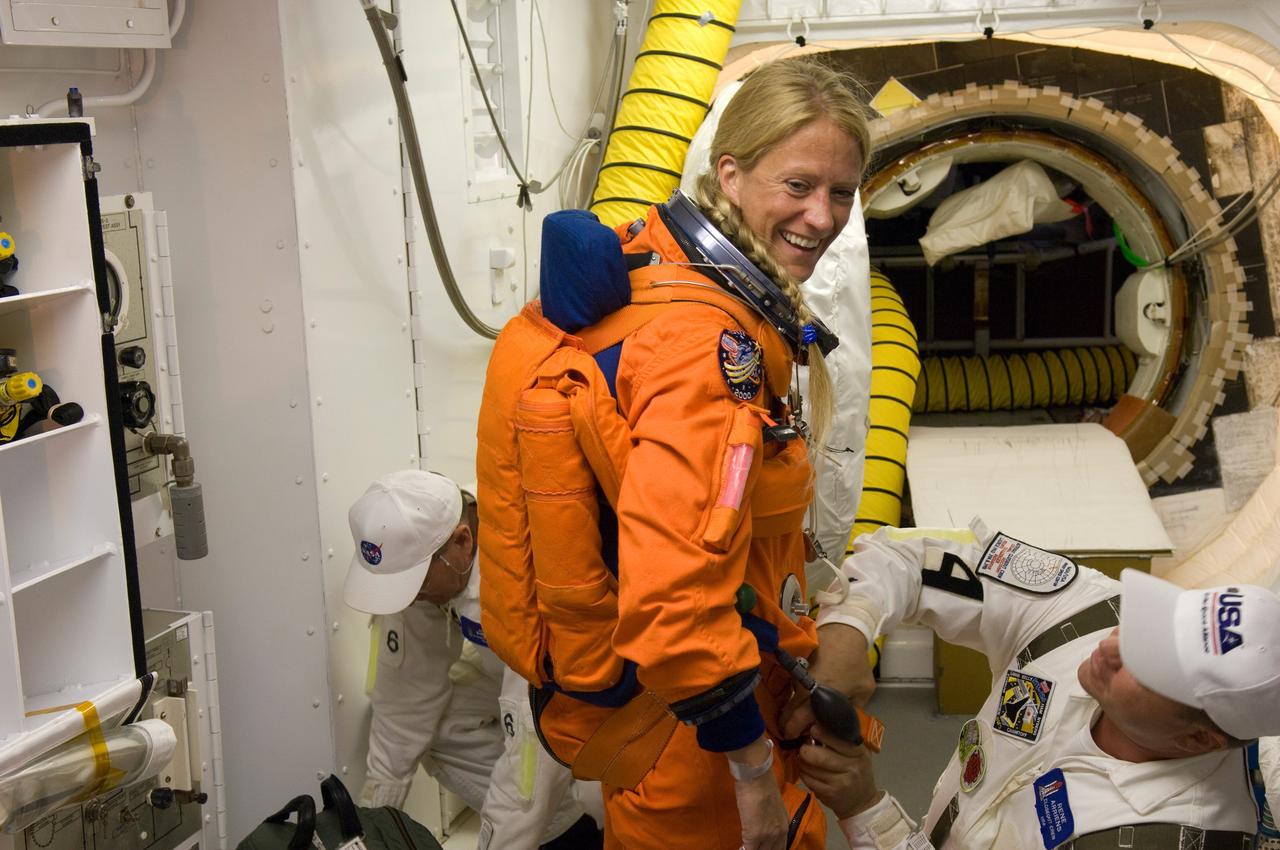 CAPE CANAVERAL, Fla. --  In the White Room on Launch Pad 39A at NASA's Kennedy Space Center, suit technicians help secure the harness over STS-124 Mission Specialist Karen Nyberg's launch and entry suit.  The White Room provides access into the shuttle.  Discovery is making its 35th flight.  The STS-124 mission is the 26th in the assembly of the space station.  It is the second of three flights launching components to complete the Japan Aerospace Exploration Agency's Kibo laboratory.  The shuttle crew will install Kibo's large Japanese Pressurized Module and its remote manipulator system, or RMS.  The 14-day flight includes three spacewalks. Photo credit: NASA/Tom Farrar, Kevin O'Connell, Scott Haun
