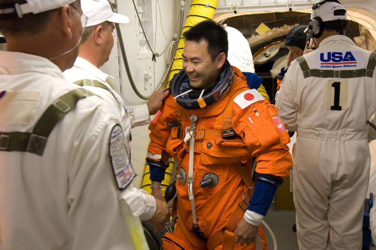 CAPE CANAVERAL, Fla. --  In the White Room on Launch Pad 39A at NASA's Kennedy Space Center, STS-124 Mission Specialist Akihiko Hoshide is helped with the harness over his launch and entry suit.  Hoshide represents the Japan Aerospace Exploration Agency.   The White Room provides access into the shuttle.  Discovery is making its 35th flight.  The STS-124 mission is the 26th in the assembly of the space station.  It is the second of three flights launching components to complete the Japan Aerospace Exploration Agency's Kibo laboratory.  The shuttle crew will install Kibo's large Japanese Pressurized Module and its remote manipulator system, or RMS.  The 14-day flight includes three spacewalks. Photo credit: NASA/Tom Farrar, Kevin O'Connell, Scott Haun