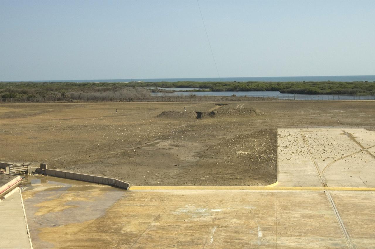 CAPE CANAVERAL, Fla. --  Debris is scattered across Launch Pad 39A at NASA's Kennedy Space Center following launch of space shuttle Discovery on its STS-124 mission.  During the post-launch walk down, the pad team noted severe launch damage on a 100’ X 20’ section of the east wall of the north flame trench. Broken sections of the flame trench wall were scattered from the flame trench to the pad perimeter fence. NASA is forming an investigation board.  The flame trench transecting the pad's mound at ground level is 490 feet long, 58 feet wide and 40 feet high. It is made of concrete and refractory brick.  The top of the solid rocket booster flame deflector abuts with that of the orbiter flame deflector to form a flattened, inverted V-shaped structure beneath the mobile launcher platform's three exhaust holes. The orbiter flame deflector is fixed and is 38 feet high, 72 feet long and 57.6 feet wide. The deflector weighs 1.3 million pounds.  The solid rocket booster deflector is 42.5 feet high, 42 feet long and 57 feet wide. The structure weighs 1.1 million pounds.  The deflectors are built of steel and covered with a high-temperature concrete surface with an average thickness of 5 inches. There are two movable solid rocket booster side flame deflectors, one located on each side of the flame trench. They are 19.5 feet high, 44 feet long and 17.5 feet wide.  Photo credit: NASA/Jim Grossmann