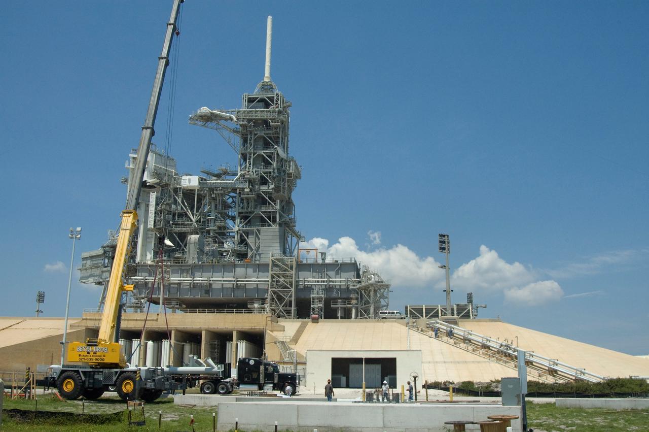 CAPE CANAVERAL, Fla. -- On Launch Pad 39B at NASA's Kennedy Space Center, a crane is removing parts of the lightning mast to be erected on towers being built for the Constellation Program and Ares/Orion launches.  Behind it are the fixed and rotating service structures on top of the pad.  An 80-foot lightning mast is on top of the fixed service structure as part of the former lightning protection system. Pad B will be the site of the first Ares vehicle launch, including Ares I-X which is scheduled for April 2009. Photo credit: NASA/Jim Grossmann