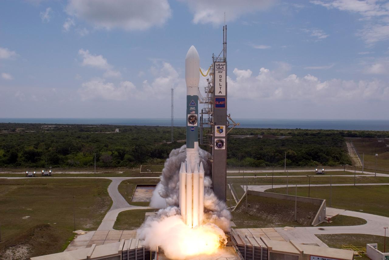 CAPE CANAVERAL, Fla.  --On Cape Canaveral Air Force Station's Launch Pad 17-B, flame and smoke mark the launch of the Delta II rocket with NASA's Gamma-Ray Large Area Space Telescope , or GLAST, aboard.  In the background can be seen the blue Atlantic Ocean between the beach and the cloud-filled sky.  Liftoff was at 12:05 p.m. EDT. GLAST is a powerful space observatory that will explore the universe's ultimate frontier, where nature harnesses forces and energies far beyond anything possible on Earth;  probe some of science's deepest questions, such as what our universe is made of, and search for new laws of physics; explain how black holes accelerate jets of material to nearly light speed; and help crack the mystery of stupendously powerful explosions known as gamma-ray bursts.  Launch is scheduled for 11:45 a.m. June 11.  Photo credit: NASA/Jerry Cannon, Robert Murray