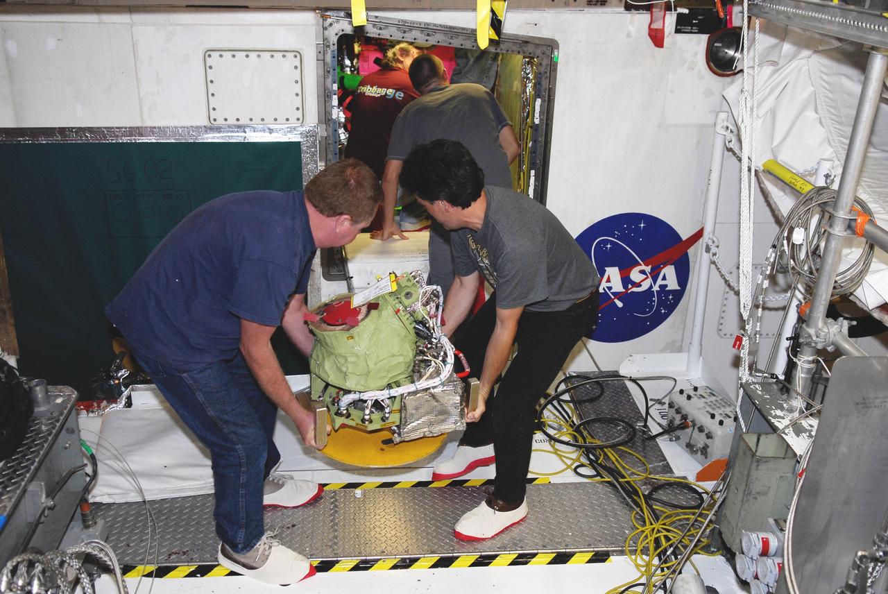 CAPE CANAVERAL, Fla. – In Orbiter Processing Facility bay No. 2, technicians begin installation of an auxiliary power unit 3, or APU3, in space shuttle Endeavour for the STS-126 mission. The auxiliary power unit is a hydrazine-fueled, turbine-driven power unit that generates mechanical shaft power to drive a hydraulic pump that produces pressure for the orbiter's hydraulic system. There are three separate APUs, three hydraulic pumps and three hydraulic systems, located in the aft fuselage of the orbiter. When the three auxiliary power units are started five minutes before lift-off, the hydraulic systems are used to position the three main engines for activation, control various propellant valves on the engines and position orbiter aerosurfaces.  The auxiliary power units are not operated after the first orbital maneuvering system thrusting period because hydraulic power is no longer required. One power unit is operated briefly one day before deorbit to support checkout of the orbiter flight control system.  One auxiliary power unit is restarted before the deorbit thrusting period. The two remaining units are started after the deorbit thrusting maneuver and operate continuously through entry, landing and landing rollout.  On STS-126, Endeavour will deliver a multi-purpose logistics module to the International Space Station. Launch is targeted for Nov. 10.  Photo credit: NASA/Kim Shiflett