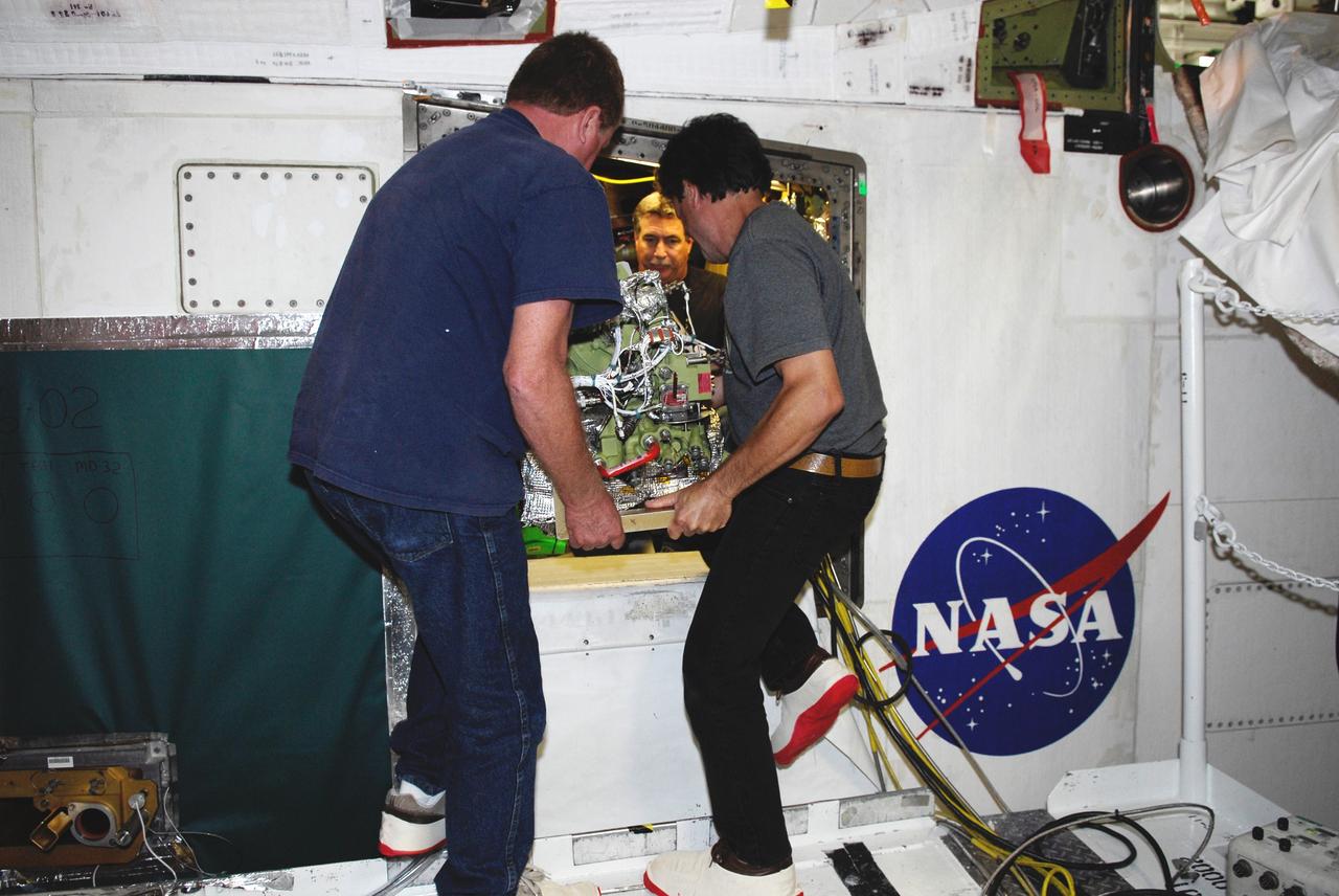CAPE CANAVERAL, Fla. – In Orbiter Processing Facility bay No. 2, technicians begin installation of an auxiliary power unit 3, or APU3, in space shuttle Endeavour for the STS-126 mission. The auxiliary power unit is a hydrazine-fueled, turbine-driven power unit that generates mechanical shaft power to drive a hydraulic pump that produces pressure for the orbiter's hydraulic system. There are three separate APUs, three hydraulic pumps and three hydraulic systems, located in the aft fuselage of the orbiter. When the three auxiliary power units are started five minutes before lift-off, the hydraulic systems are used to position the three main engines for activation, control various propellant valves on the engines and position orbiter aerosurfaces.  The auxiliary power units are not operated after the first orbital maneuvering system thrusting period because hydraulic power is no longer required. One power unit is operated briefly one day before deorbit to support checkout of the orbiter flight control system.  One auxiliary power unit is restarted before the deorbit thrusting period. The two remaining units are started after the deorbit thrusting maneuver and operate continuously through entry, landing and landing rollout.  On STS-126, Endeavour will deliver a multi-purpose logistics module to the International Space Station. Launch is targeted for Nov. 10.  Photo credit: NASA/Kim Shiflett