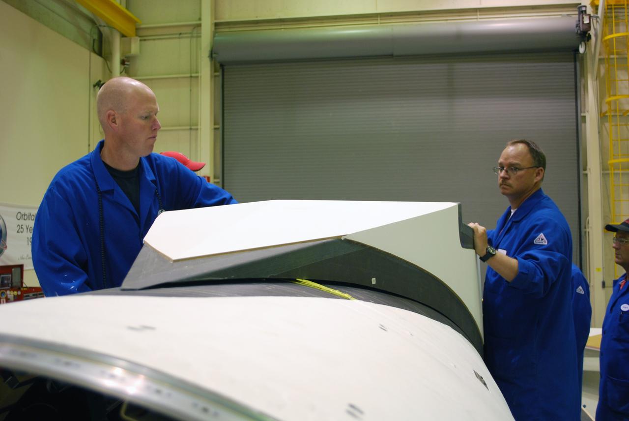VANDENBERG AIR FORCE BASE, Calif. – In Building 1555, workers secure the fillet into place on the Pegasus XL launch vehicle. The Pegasus will launch NASA's Interstellar Boundary Explorer Mission, or IBEX, satellite from Kwajalein Island in the Marshall Islands, South Pacific. IBEX will make the first map of the boundary between the solar system and interstellar space. IBEX is the first mission designed to detect the edge of the solar system. As the solar wind from the sun flows out beyond Pluto, it collides with the material between the stars, forming a shock front. IBEX contains two neutral atom imagers designed to detect particles from the termination shock at the boundary between the solar system and interstellar space. IBEX also will study galactic cosmic rays, energetic particles from beyond the solar system that pose a health and safety hazard for humans exploring beyond Earth orbit. IBEX will make these observations from a highly elliptical orbit that takes it beyond the interference of the Earth's magnetosphere. Photo credit: NASA/Randy Beaudoin