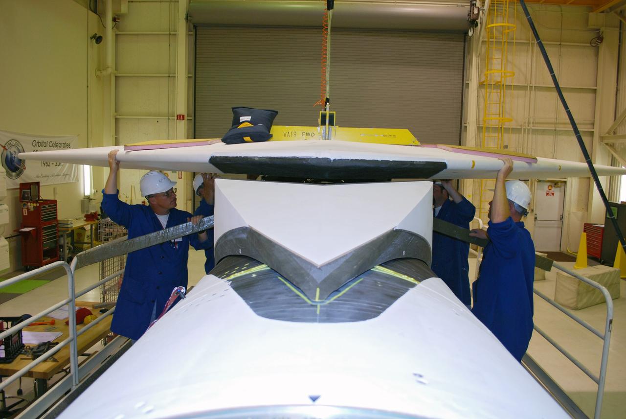 VANDENBERG AIR FORCE BASE, Calif. – In Building 1555, workers check the fit of the wing on the Pegasus XL launch vehicle. The Pegasus will launch NASA's Interstellar Boundary Explorer Mission, or IBEX, satellite from Kwajalein Island in the Marshall Islands, South Pacific. IBEX will make the first map of the boundary between the solar system and interstellar space. IBEX is the first mission designed to detect the edge of the solar system. As the solar wind from the sun flows out beyond Pluto, it collides with the material between the stars, forming a shock front. IBEX contains two neutral atom imagers designed to detect particles from the termination shock at the boundary between the solar system and interstellar space. IBEX also will study galactic cosmic rays, energetic particles from beyond the solar system that pose a health and safety hazard for humans exploring beyond Earth orbit. IBEX will make these observations from a highly elliptical orbit that takes it beyond the interference of the Earth's magnetosphere. Photo credit: NASA/Randy Beaudoin