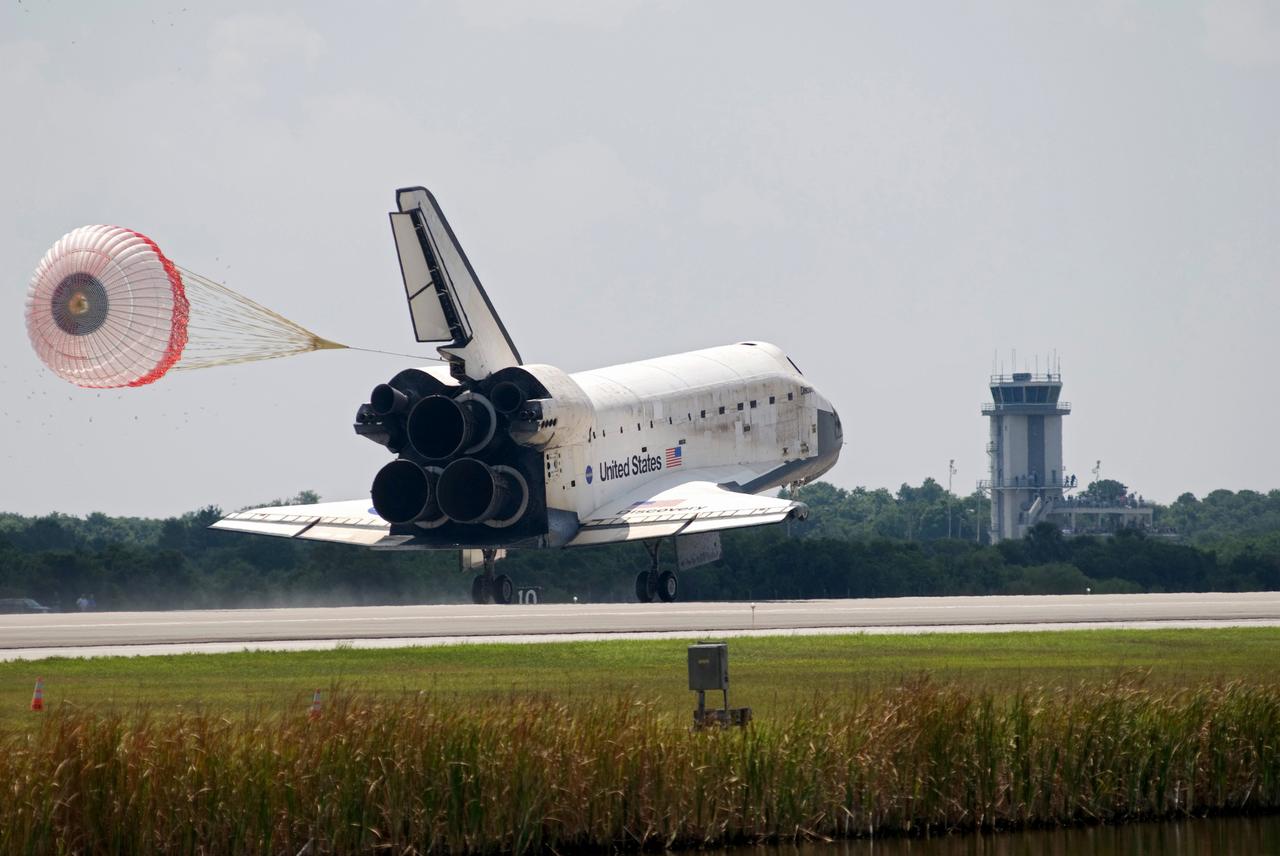CAPE CANAVERAL, Fla. – Release of the drag chute helps slow space shuttle Discovery's landing as it touches down on Runway 15 to end the STS-124 mission, a 14-day flight to the International Space Station. This landing was the 69th at NASA's Kennedy Space Center. In the background, at left, is the Vehicle Assembly Building. The main landing gear touched down at 11:15:19 a.m. EDT. The nose landing gear touched down at 11:15:30 a.m. and wheel stop was at 11:16:19 a.m. The mission completed 5.7 million miles. The STS-124 mission delivered the Japan Aerospace Exploration Agency's large Japanese Pressurized Module and its remote manipulator system to the space station. Photo credit: NASA/Tom Joseph