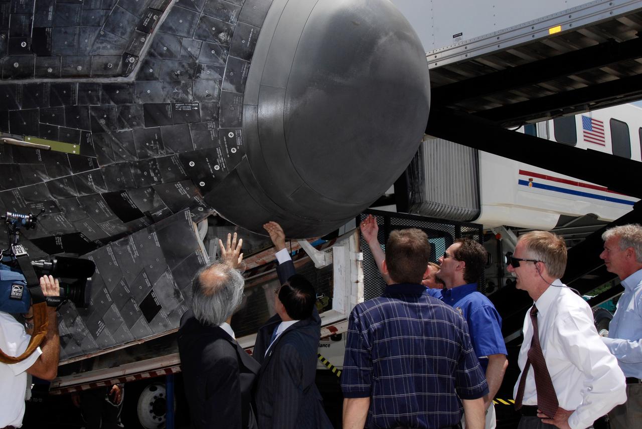 CAPE CANAVERAL, Fla.  –  NASA and Japanese VIPs try to sense any heat still resident in the nose cone of space shuttle Discovery after its landing on Runway 15 at NASA's Kennedy Space Center.  From left are the Japan Aerospace Exploration Agency's  Director of Program Management and Integration Yuichi Yamaura and Vice President Kaoru Mamiya, Kennedy's Director of Mission Launch Integration LeRoy Cain and NASA Associate Administrator for Space Operations Bill Gerstenmaier (white shirt).  Discovery's landing ended the STS-124 mission, a 14-day flight to the International Space Station.  The main landing gear touched down at 11:15:19 a.m. EDT. The nose landing gear touched down at 11:15:30 a.m. and wheel stop was at 11:16:19 a.m. The mission completed 5.7 million miles. The STS-124 mission delivered the Japan Aerospace Exploration Agency's large Japanese Pressurized Module and its remote manipulator system to the space station.   Photo credit: NASA/Kim Shiflett