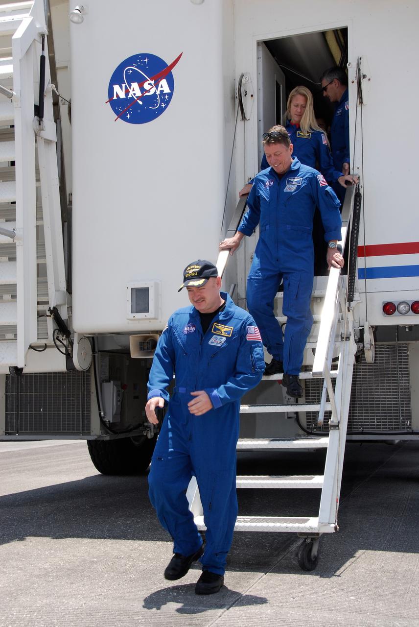 CAPE CANAVERAL, Fla. – After their successful STS-124 mission and landing at NASA's Kennedy Space Center, crew members exit the crew transport vehicle. Leading the way is Commander Mark Kelly, followed by Mission Specialists Mike Fossum and Karen Nyberg. Space shuttle Discovery's main landing gear touched down at 11:15:19 a.m. EDT on Runway 15. The nose landing gear touched down at 11:15:30 a.m. and wheel stop was at 11:16:19 a.m. The mission completed 5.7 million miles. The STS-124 mission delivered the Japan Aerospace Exploration Agency's large Japanese Pressurized Module and its remote manipulator system to the space station. Photo credit: NASA/Kim Shiflett