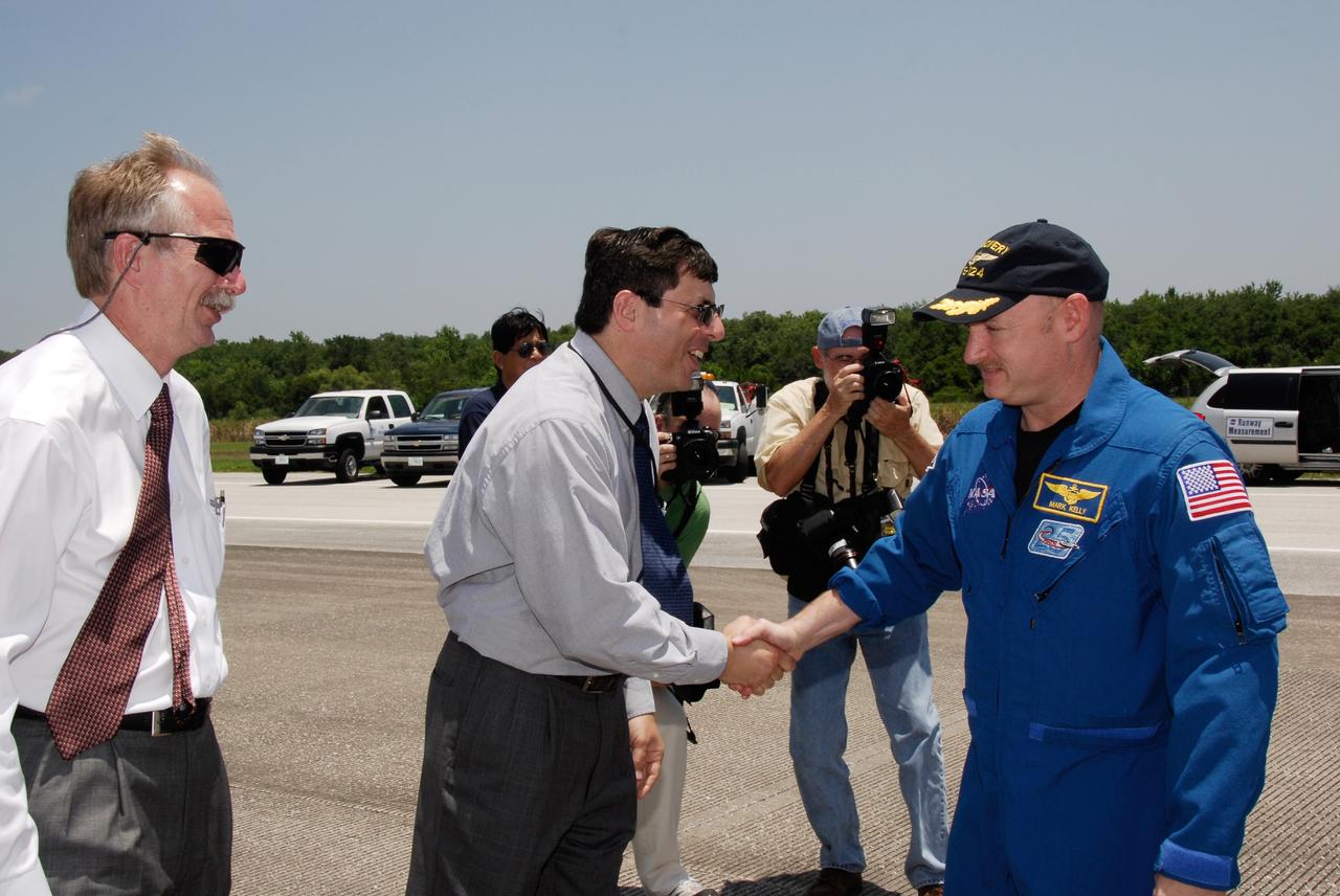 CAPE CANAVERAL, Fla. – After the successful STS-124 mission and landing on Runway 15 at NASA's Kennedy Space Center, Commander Mark Kelly is greeted by NASA Associate Administrator Chris Scolese. At left is Associate Administrator for Space Operations Bill Gerstenmaier. Space shuttle Discovery's main landing gear touched down at 11:15:19 a.m. EDT on Runway 15. The nose landing gear touched down at 11:15:30 a.m. and wheel stop was at 11:16:19 a.m. The mission completed 5.7 million miles. The STS-124 mission delivered the Japan Aerospace Exploration Agency's large Japanese Pressurized Module and its remote manipulator system to the space station. Photo credit: NASA/Kim Shiflett