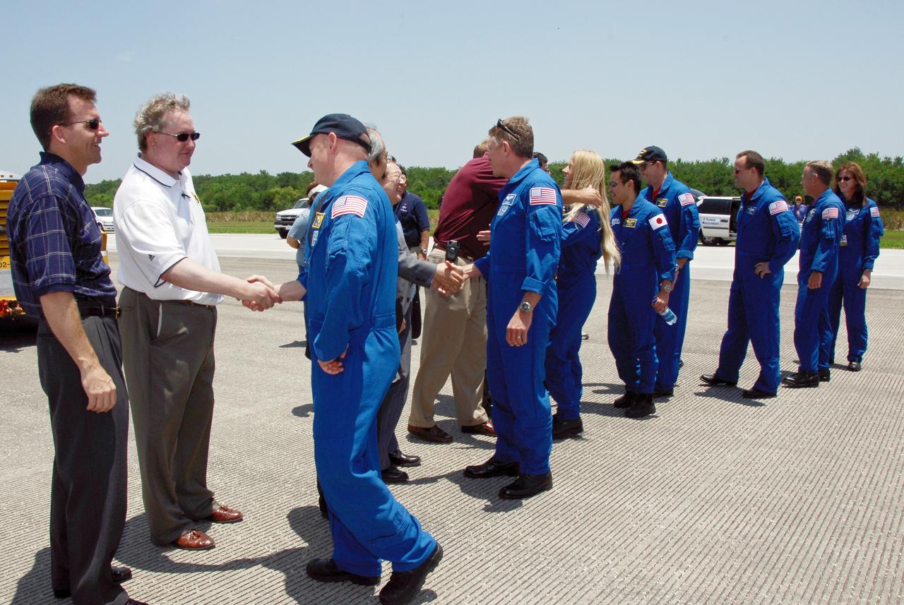 CAPE CANAVERAL, Fla.  –  After the successful STS-124 mission and landing on Runway 15 at NASA's Kennedy Space Center, the crew members are greeted by the Director of Mission Launch Integration LeRoy Cain( far left), the Japan Aerospace Exploration Agency's Director of Program Management and Integration Yuichi Yamaura and Vice President Kaoru Mamiya (center) and Center Director Bill Parsons (right).  The crew members, from left, are Commander Mark Kelly, Mission Specialists Mike Fossum, Karen Nyberg and Akihiko Hoshide, Pilot Ken Ham and Mission Specialist Ron Garan. Other astronauts accompany them.  Space shuttle Discovery's main landing gear touched down at 11:15:19 a.m. EDT on Runway 15. The nose landing gear touched down at 11:15:30 a.m. and wheel stop was at 11:16:19 a.m. The mission completed 5.7 million miles. The STS-124 mission delivered the Japan Aerospace Exploration Agency's large Japanese Pressurized Module and its remote manipulator system to the space station.   Photo credit: NASA/Kim Shiflett