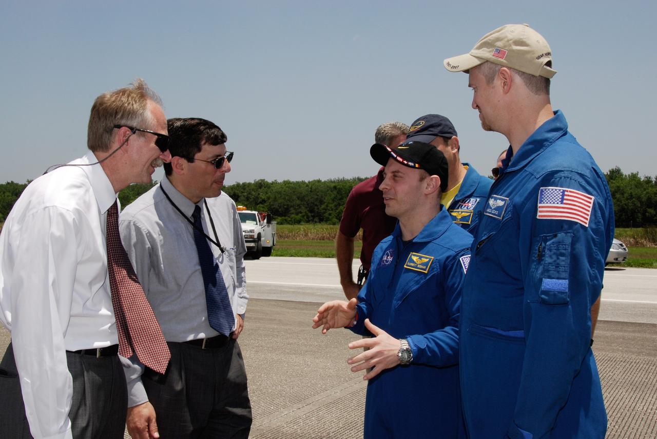 CAPE CANAVERAL, Fla. – After landing with the STS-124 mission crew, astronaut Garrett Reisman talks to NASA Associate Administrator for Space Operations Bill Gerstenmaier and NASA Associate Administrator Chris Scolese. Reisman spent 95 days on the International Space Station as part of the Expedition 17 crew. The STS-124 mission ended with space shuttle Discovery's landing on Runway 15 at NASA's Kennedy Space Center, ending a 14-day mission to the International Space Station. Discovery's main landing gear touched down at 11:15:19 a.m. EDT on Runway 15. The nose landing gear touched down at 11:15:30 a.m. and wheel stop was at 11:16:19 a.m. The mission completed 5.7 million miles. The STS-124 mission delivered the Japan Aerospace Exploration Agency's large Japanese Pressurized Module and its remote manipulator system to the space station. Photo credit: NASA/Kim Shiflett