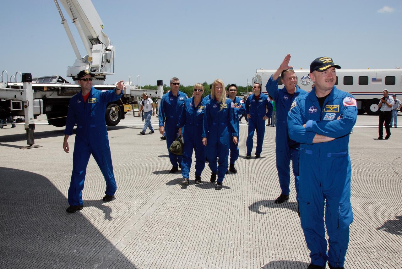 CAPE CANAVERAL, Fla. – The STS-124 mission crew members head for their traditional walk-around space shuttle Discovery after landing on Runway 15 at NASA's Kennedy Space Center, ending a 14-day mission to the International Space Station. At left is Pilot Ken Ham, in center is Mission Specialist Karen Nyberg, followed by Mission Specialists Akihiko Hoshide and Ron Garan. At right are Mission Specialist Mike Fossum and Commander Mark Kelly. Discovery's main landing gear touched down at 11:15:19 a.m. EDT on Runway 15. The nose landing gear touched down at 11:15:30 a.m. and wheel stop was at 11:16:19 a.m. The mission completed 5.7 million miles. The STS-124 mission delivered the Japan Aerospace Exploration Agency's large Japanese Pressurized Module and its remote manipulator system to the space station. Photo credit: NASA/Kim Shiflett