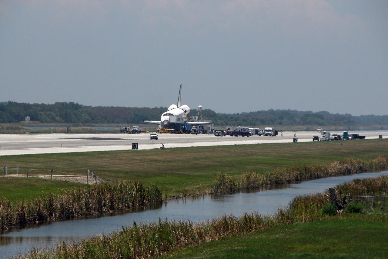 CAPE CANAVERAL, Fla.  –  A crew transport vehicle, or CTV, approaches space shuttle Discovery on the Shuttle Landing Facility at NASA's Kennedy Space Center.  Discovery landed on Runway 15, ending the 14-day, STS-124 mission to the International Space Station.   Discovery has been purged -- providing cool and humidified air conditioning to the payload bay and other cavities to remove any residual explosive or toxic fumes – while still on the runway. Cooling transfer to ground services occurs at about the same time, allowing onboard cooling to be shut down. When it is determined that the area in and around the orbiter is safe, the crew will departure from the orbiter to the CTV. The STS-124 mission delivered the Japan Aerospace Exploration Agency's large Japanese Pressurized Module and its remote manipulator system to the space station.  Photo credit: NASA/Kim Shiflett