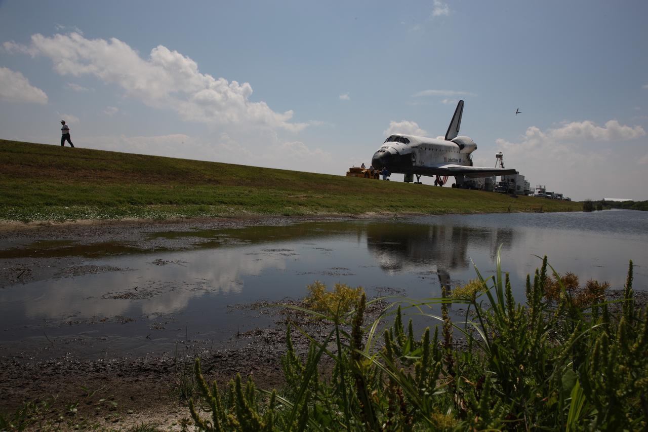 CAPE CANAVERAL, Fla. – Nearby water reflects space shuttle Discovery as it is towed from the Shuttle Landing Facility at NASA's Kennedy Space Center. Discovery's landing ended the 14-day, STS-124 mission to the International Space Station. The STS-124 mission delivered the Japan Aerospace Exploration Agency's large Japanese Pressurized Module and its remote manipulator system to the International Space Station. The landing was on time at 11:15 a.m. EDT. Photo courtesy of Scott Andrews.