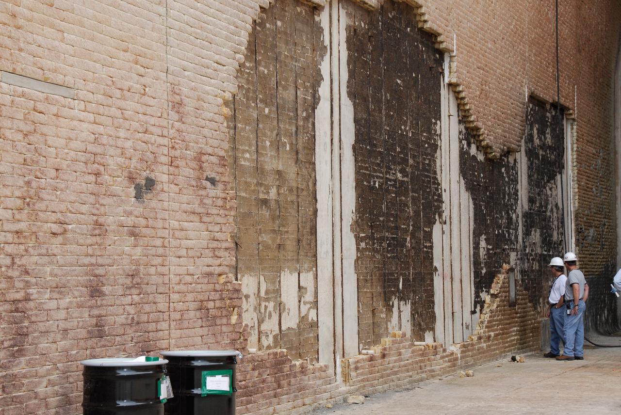 CAPE CANAVERAL, Fla. – Workers examine some of the damage to the wall of the flame trench on Launch Pad 39A at NASA's Kennedy Space Center where damage occurred during the May 31 launch of space shuttle Discovery. Repairs are expected to be completed in time for space shuttle Atlantis' STS-125 mission to NASA's Hubble Space Telescope targeted for Oct. 8. Photo credit: NASA/Kim Shiflett