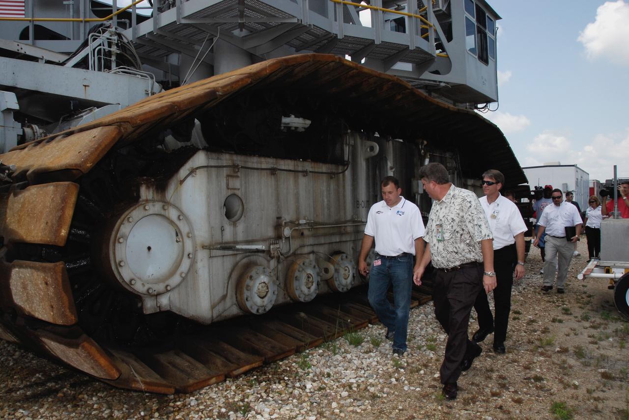 CAPE CANAVERAL, Fla.  –   2008 Daytona 500 winner Ryan Newman (left) gets a close look at a crawler-transporter with Perry Becker, chief of the Shuttle Grounds Structural Branch, at NASA's Kennedy Space Center.  Unlike his winning race car, the maximum speed of a crawler is 2 mph unloaded.  Newman is visiting Kennedy in honor of NASA's 50th anniversary and the 50th running of NASCAR's Daytona 500 in February. NASA presented Newman two green racing flags that were flown last February aboard space shuttle Atlantis' STS-122 mission to the International Space Station. One flag was given to Newman, the second was presented to Daytona 500 Experience General Manager Kim Isemann. A third flag that was flown will be kept by NASA for public display.  The connection between NASA and Daytona's International Speedway extends beyond their close proximity to one another. During recent years, technology developed for the space program has found many uses on Earth, including helping NASCAR drivers stay safe and increase performance.  Photo credit: NASA/Kim Shiflett
