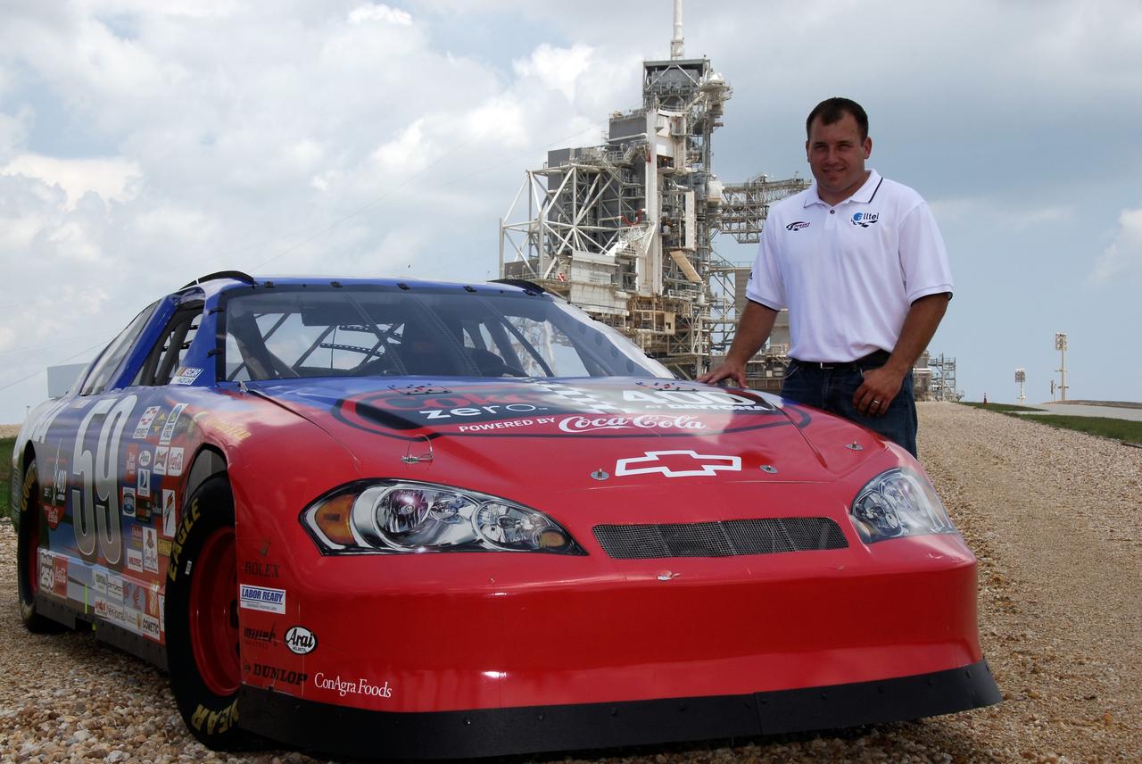 CAPE CANAVERAL, Fla.  –   On Launch Pad 39A at NASA's Kennedy Space Center, 2008 Daytona 500 winner Ryan Newman poses for photographers with the Daytona International Speedway show car.  Newman is visiting Kennedy in honor of NASA's 50th anniversary and the 50th running of NASCAR's Daytona 500 in February. NASA presented Newman two green racing flags that were flown last February aboard space shuttle Atlantis' STS-122 mission to the International Space Station. One flag was given to Newman, the second was presented to Daytona 500 Experience General Manager Kim Isemann. A third flag that was flown will be kept by NASA for public display.  The connection between NASA and Daytona's International Speedway extends beyond their close proximity to one another. During recent years, technology developed for the space program has found many uses on Earth, including helping NASCAR drivers stay safe and increase performance.  Photo credit: NASA/Kim Shiflett