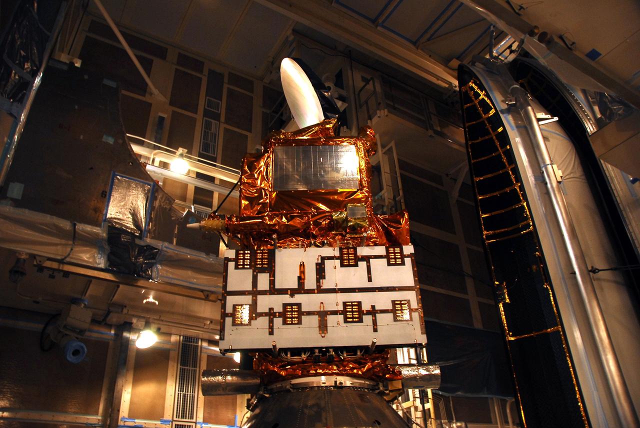 VANDENBERG AIR FORCE BASE, Calif. –   In the mobile service tower on Space Launch Complex 2, the first half of the fairing (at right) is being moved toward the Ocean Surface Topography Mission, or OSTM/Jason 2, spacecraft for encapsulation.  The fairing is a molded structure that fits flush with the outside surface of the Delta II upper stage booster and forms an aerodynamically smooth nose cone, protecting the spacecraft during launch and ascent. The launch of the OSTM/Jason-2 is scheduled for June 20 from Vandenberg Air Force Base. The launch window extends from 12:46 a.m. to 12:55 a.m. PDT. The satellite will be placed in an 830-mile-high orbit at an inclination of 66 degrees after separating from the Delta II 55 minutes after liftoff.  The five primary science instruments of the Ocean Surface Topography Mission aboard the Jason 2 spacecraft are dedicated to measuring the height of the ocean surface. These measurements will be used to evaluate and forecast climate changes and improve weather forecasting. The results also are expected to help forecasters better predict hurricane intensity.