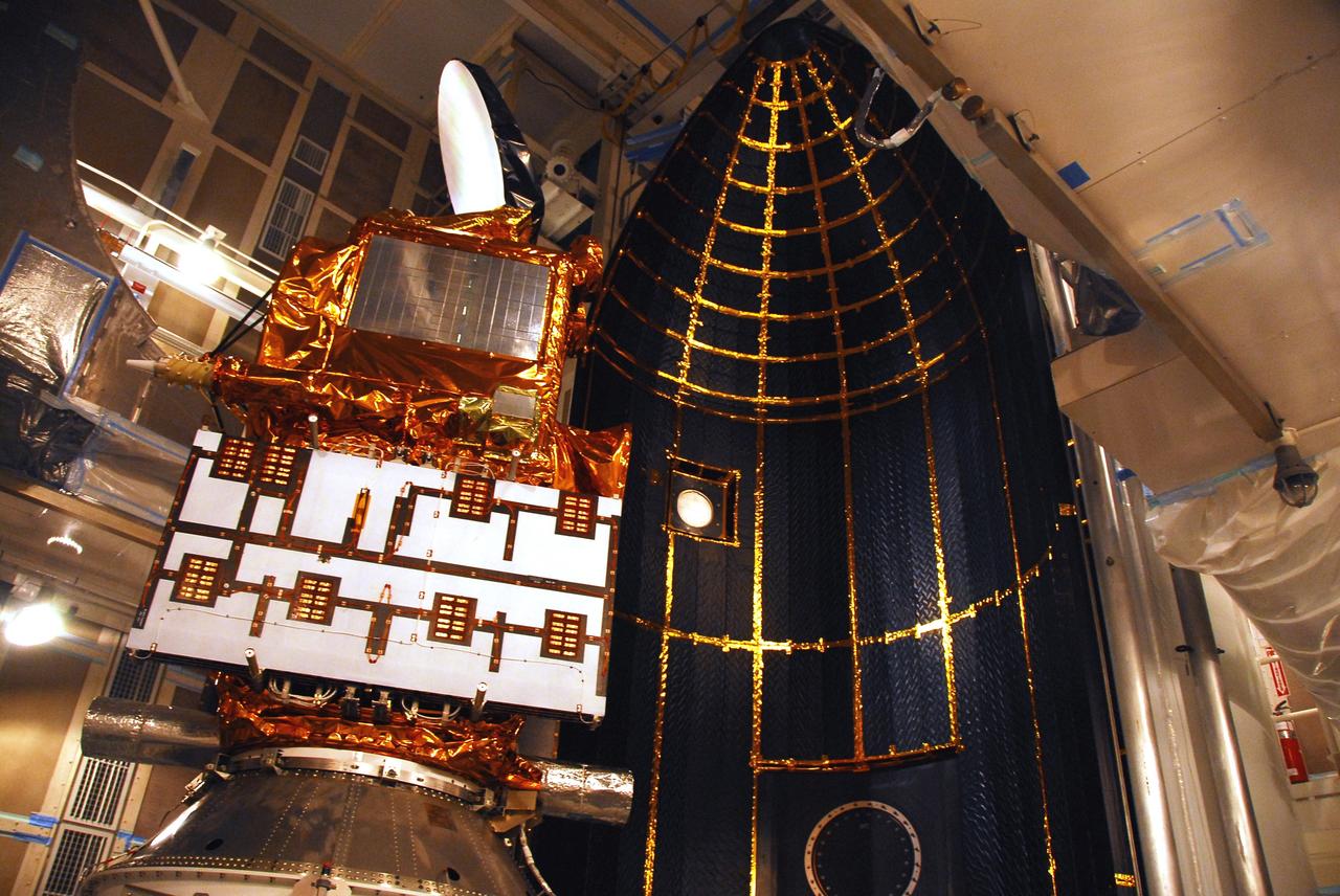 VANDENBERG AIR FORCE BASE, Calif. –  In the mobile service tower on Space Launch Complex 2, the first half of the fairing (at right) is moved closer toward the Ocean Surface Topography Mission, or OSTM/Jason 2, spacecraft for encapsulation. The fairing is a molded structure that fits flush with the outside surface of the Delta II upper stage booster and forms an aerodynamically smooth nose cone, protecting the spacecraft during launch and ascent. The launch of the OSTM/Jason-2 is scheduled for June 20 from Vandenberg Air Force Base. The launch window extends from 12:46 a.m. to 12:55 a.m. PDT. The satellite will be placed in an 830-mile-high orbit at an inclination of 66 degrees after separating from the Delta II 55 minutes after liftoff.  The five primary science instruments of the Ocean Surface Topography Mission aboard the Jason 2 spacecraft are dedicated to measuring the height of the ocean surface. These measurements will be used to evaluate and forecast climate changes and improve weather forecasting. The results also are expected to help forecasters better predict hurricane intensity.