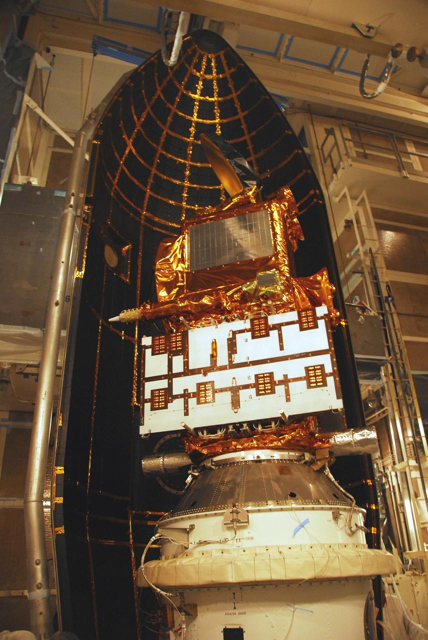 VANDENBERG AIR FORCE BASE, Calif. –  In the mobile service tower on Space Launch Complex 2, the first half of the fairing moves into place behind the Ocean Surface Topography Mission, or OSTM/Jason 2, spacecraft for encapsulation. The fairing is a molded structure that fits flush with the outside surface of the Delta II upper stage booster and forms an aerodynamically smooth nose cone, protecting the spacecraft during launch and ascent. The launch of the OSTM/Jason-2 is scheduled for June 20 from Vandenberg Air Force Base. The launch window extends from 12:46 a.m. to 12:55 a.m. PDT. The satellite will be placed in an 830-mile-high orbit at an inclination of 66 degrees after separating from the Delta II 55 minutes after liftoff.  The five primary science instruments of the Ocean Surface Topography Mission aboard the Jason 2 spacecraft are dedicated to measuring the height of the ocean surface. These measurements will be used to evaluate and forecast climate changes and improve weather forecasting. The results also are expected to help forecasters better predict hurricane intensity.