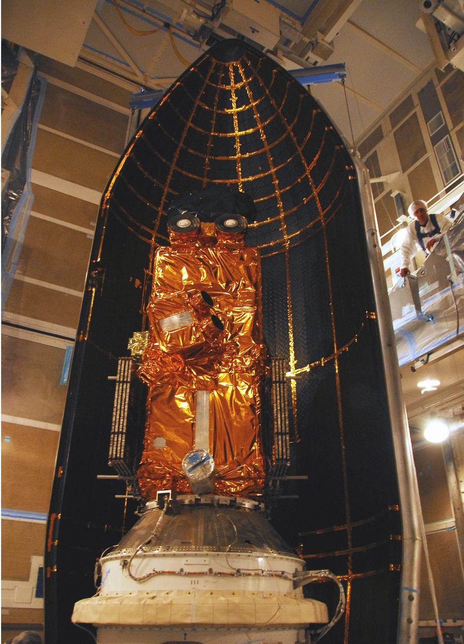 VANDENBERG AIR FORCE BASE, Calif. –   In the mobile service tower on Space Launch Complex 2, the first half of the fairing moves into place behind the Ocean Surface Topography Mission, or OSTM/Jason 2, spacecraft for encapsulation. The fairing is a molded structure that fits flush with the outside surface of the Delta II upper stage booster and forms an aerodynamically smooth nose cone, protecting the spacecraft during launch and ascent. The launch of the OSTM/Jason-2 is scheduled for June 20 from Vandenberg Air Force Base. The launch window extends from 12:46 a.m. to 12:55 a.m. PDT. The satellite will be placed in an 830-mile-high orbit at an inclination of 66 degrees after separating from the Delta II 55 minutes after liftoff.  The five primary science instruments of the Ocean Surface Topography Mission aboard the Jason 2 spacecraft are dedicated to measuring the height of the ocean surface. These measurements will be used to evaluate and forecast climate changes and improve weather forecasting. The results also are expected to help forecasters better predict hurricane intensity.
