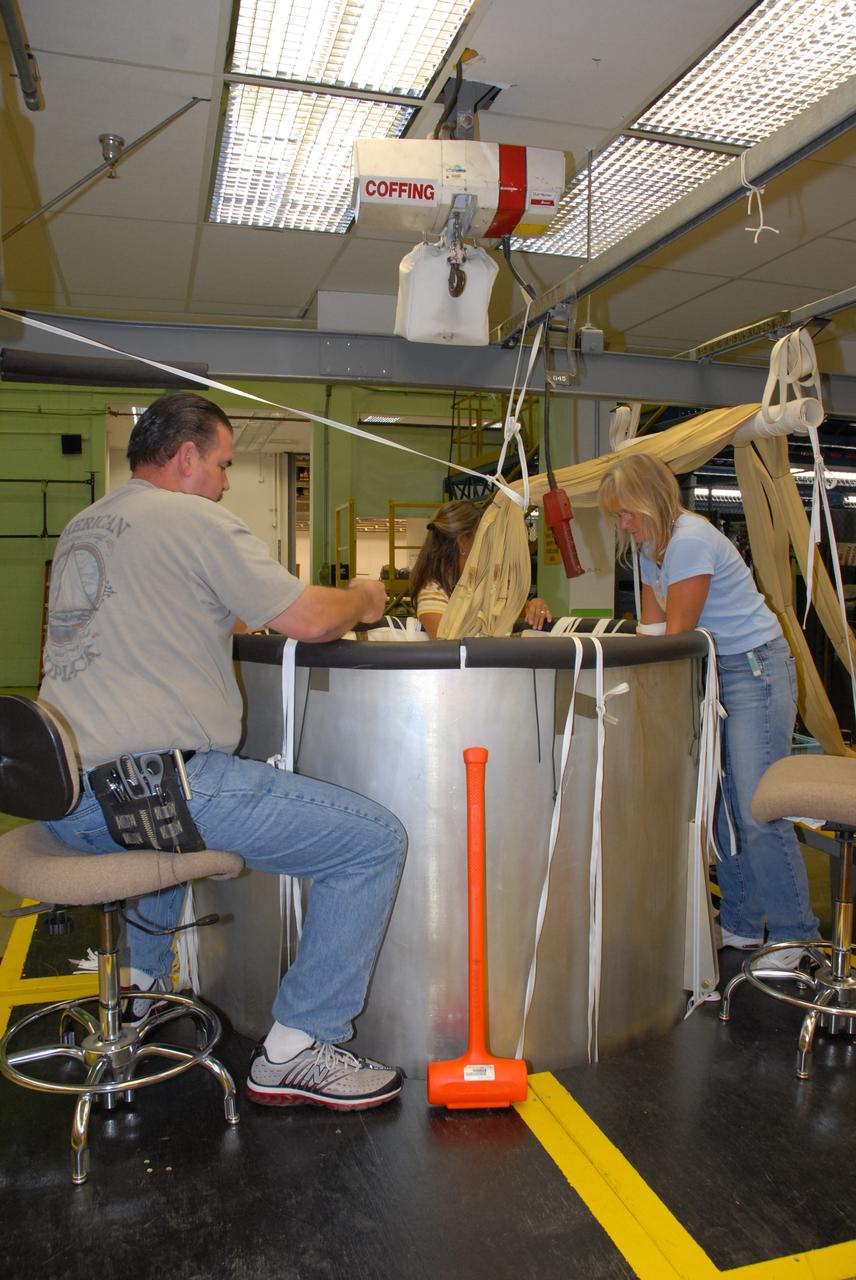 CAPE CANAVERAL, Fla. – In the Parachute Refurbishment Facility at NASA's Kennedy Space Center, parachutes for the Ares rockets are being packed. Ares I is an in-line, two-stage rocket that will transport the Orion crew exploration vehicle to low-Earth orbit. The Ares I first stage will be a five-segment solid rocket booster based on the four-segment design used for the shuttle. As with the shuttle, this booster will fall away when spent, lowered by parachute into the Atlantic Ocean where it can be retrieved for re-use. Unlike the shuttle, the booster will be flying faster, at Mach 6, when its separation from the rest of Ares I occurs. Photo credit: NASA/Jack Pfaller