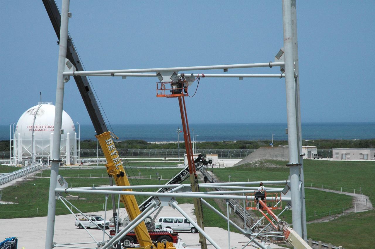 CAPE CANAVERAL, Fla. – With the backdrop of a blue sky and the blue Atlantic Ocean, workers are constructing the lightning towers on Launch Pad 39B at NASA's Kennedy Space Center. In the background, at left, is the liquid hydrogen tank that helps fuel a space shuttle for launch. Each of the three new lightning towers will be 500 feet tall with an additional 100-foot fiberglass mast atop supporting a wire centenary system. This improved lightning protection system also allows for the taller height of the Ares I compared to the space shuttle. Pad B will be the site of the first Ares vehicle launch, including Ares I-X which is scheduled for April 2009, as part of the Constellation Program. Photo credit: NASA/Jim Grossmann