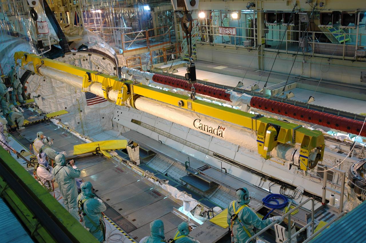 CAPE CANAVERAL, Fla. – In the Orbiter Processing Facility bay 3, space shuttle Discovery's robotic arm is lowered into the payload bay for installation. Scheduled to launch on the STS-119 mission, Discovery will carry the S6 truss segment to complete the 361-foot-long backbone of the International Space Station. The truss includes the fourth pair of solar array wings and electronics that convert sunlight to power for the orbiting laboratory. A launch date has not yet been determined. Photo credit: NASA/Jim Grossmann