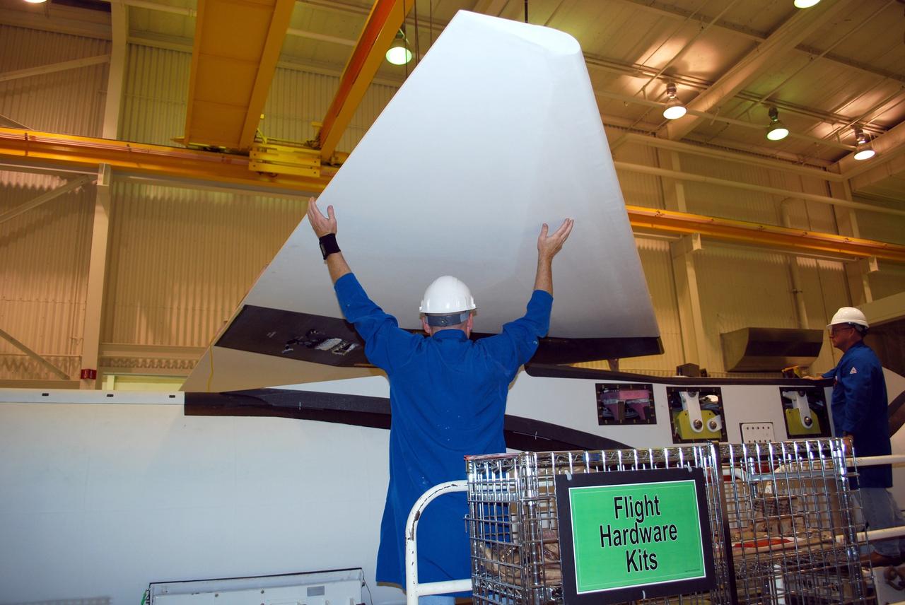 VANDENBERG AIR FORCE BASE, Calif. -- Workers in Building 1555 at Vandenberg AFB help maneuver the wing for installation onto the Pegasus rocket. The Pegasus will launch NASA's Interstellar Boundary Explorer Mission, or IBEX, satellite from Kwajalein Island in the Marshall Islands, South Pacific. IBEX will make the first map of the boundary between the solar system and interstellar space. IBEX is the first mission designed to detect the edge of the solar system. As the solar wind from the sun flows out beyond Pluto, it collides with the material between the stars, forming a shock front. IBEX contains two neutral atom imagers designed to detect particles from the termination shock at the boundary between the solar system and interstellar space. IBEX also will study galactic cosmic rays, energetic particles from beyond the solar system that pose a health and safety hazard for humans exploring beyond Earth orbit. IBEX will make these observations from a highly elliptical orbit that takes it beyond the interference of the Earth's magnetosphere. IBEX is targeted for launch in September 2008. Photo credit: NASA/ Randy Beaudoin