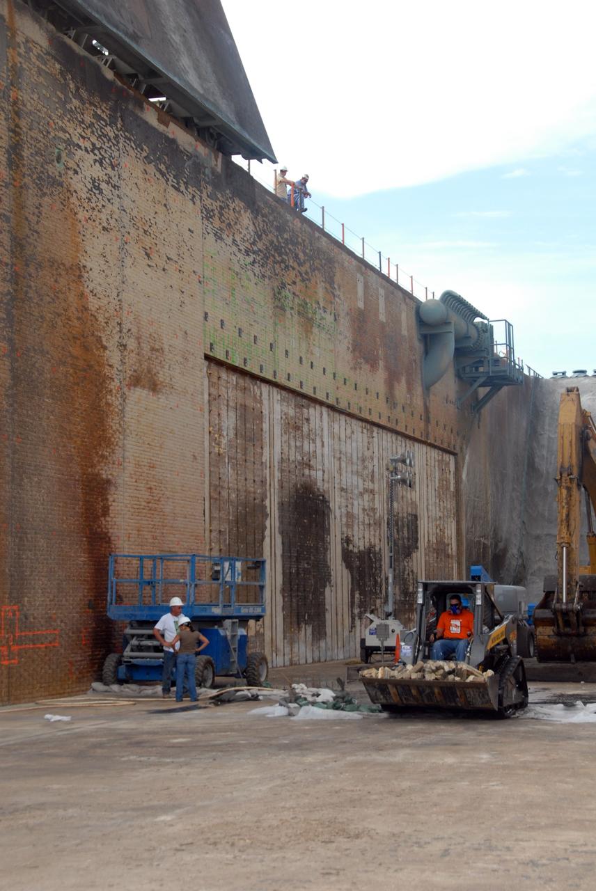 CAPE CANAVERAL, Fla. – Crews remove bricks from the damaged walls of the flame trench on Launch Pad 39A at NASA's Kennedy Space Center.  Damage to the trench occurred during the launch of Discovery on the STS-124 mission.  A 75- by 20-foot section of the east wall was destroyed and debris scattered as far as the pad perimeter fence.  Repairs are expected to be completed before the targeted Oct. 8 launch of Atlantis on the STS-125 mission.  Photo credit: NASA/Jack Pfaller