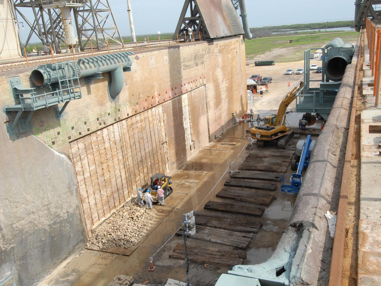 CAPE CANAVERAL, Fla. – A view into the flame trench on Launch Pad 39A at NASA's Kennedy Space Center shows more repair work under way. Damage to the trench occurred during the launch of Discovery on the STS-124 mission. A 75- by 20-foot section of the east wall was destroyed and debris scattered as far as the pad perimeter fence. Repairs are expected to be completed before the targeted Oct. 8 launch of Atlantis on the STS-125 mission. Photo credit: NASA/Jack Pfaller