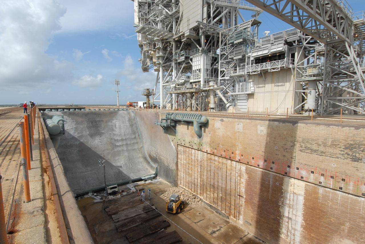 CAPE CANAVERAL, Fla. –   A view from above the flame trench on Launch Pad 39A at NASA's Kennedy Space Center shows more repair work under way.  The mobile launcher platform, with the space shuttle on top, straddles the trench during launch.  Damage to the trench occurred during the launch of Discovery on the STS-124 mission.  A 75- by 20-foot section of the east wall was destroyed and debris scattered as far as the pad perimeter fence.  Repairs are expected to be completed before the targeted Oct. 8 launch of Atlantis on the STS-125 mission.  Photo credit: NASA/Jack Pfaller