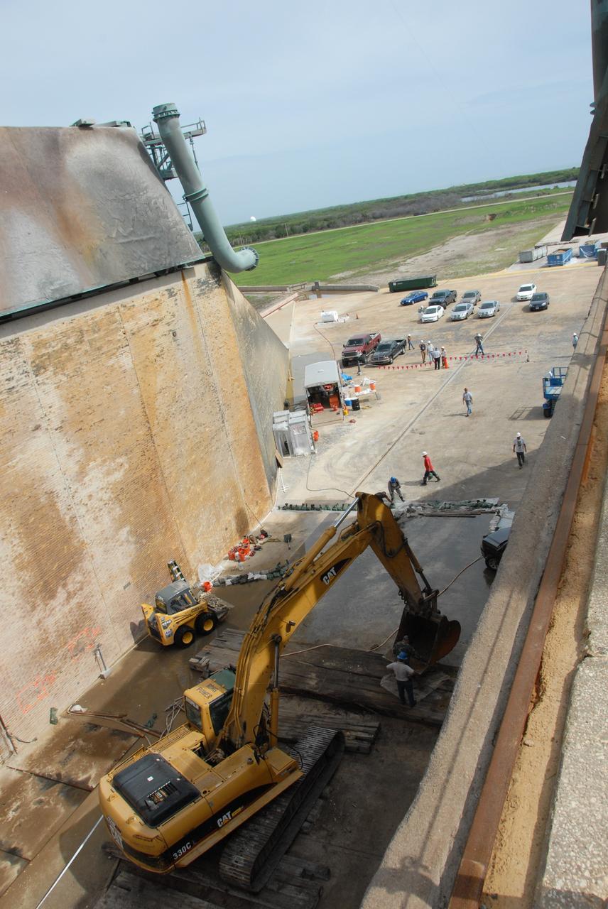 CAPE CANAVERAL, Fla. – A backhoe is being used during repair work under way on the flame trench on Launch Pad 39A at NASA's Kennedy Space Center. Damage to the trench occurred during the launch of Discovery on the STS-124 mission. A 75- by 20-foot section of the east wall was destroyed and debris scattered as far as the pad perimeter fence. Repairs are expected to be completed before the targeted Oct. 8 launch of Atlantis on the STS-125 mission. Photo credit: NASA/Jack Pfaller