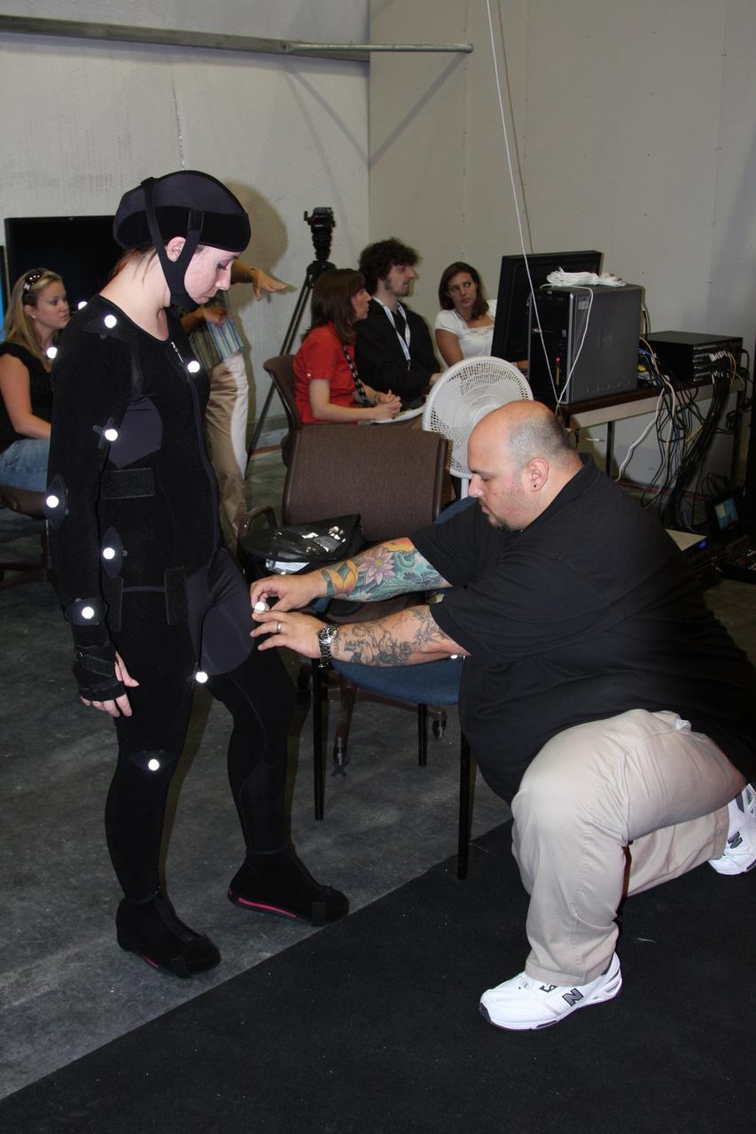 CAPE CANAVERAL, Fla. –David Voci, NYIT MOCAP (Motion Capture) team co-director (seated at the workstation in the background) prepares to direct a motion capture session assisted by Kennedy Advanced Visualizations Environment staff led by Brad Lawrence (not pictured) and by Lora Ridgwell from United Space Alliance Human Factors (foreground, left). Ridgwell will help assemble the Orion Crew Module mockup. The motion tracking aims to improve efficiency of assembly processes and identify potential ergonomic risks for technicians assembling the mockup. The work is being performed in United Space Alliance's Human Engineering Modeling and Performance Lab in the RLV Hangar at NASA's Kennedy Space Center. Part of NASA's Constellation Program, the Orion spacecraft will return humans to the moon and prepare for future voyages to Mars and other destinations in our solar system.
